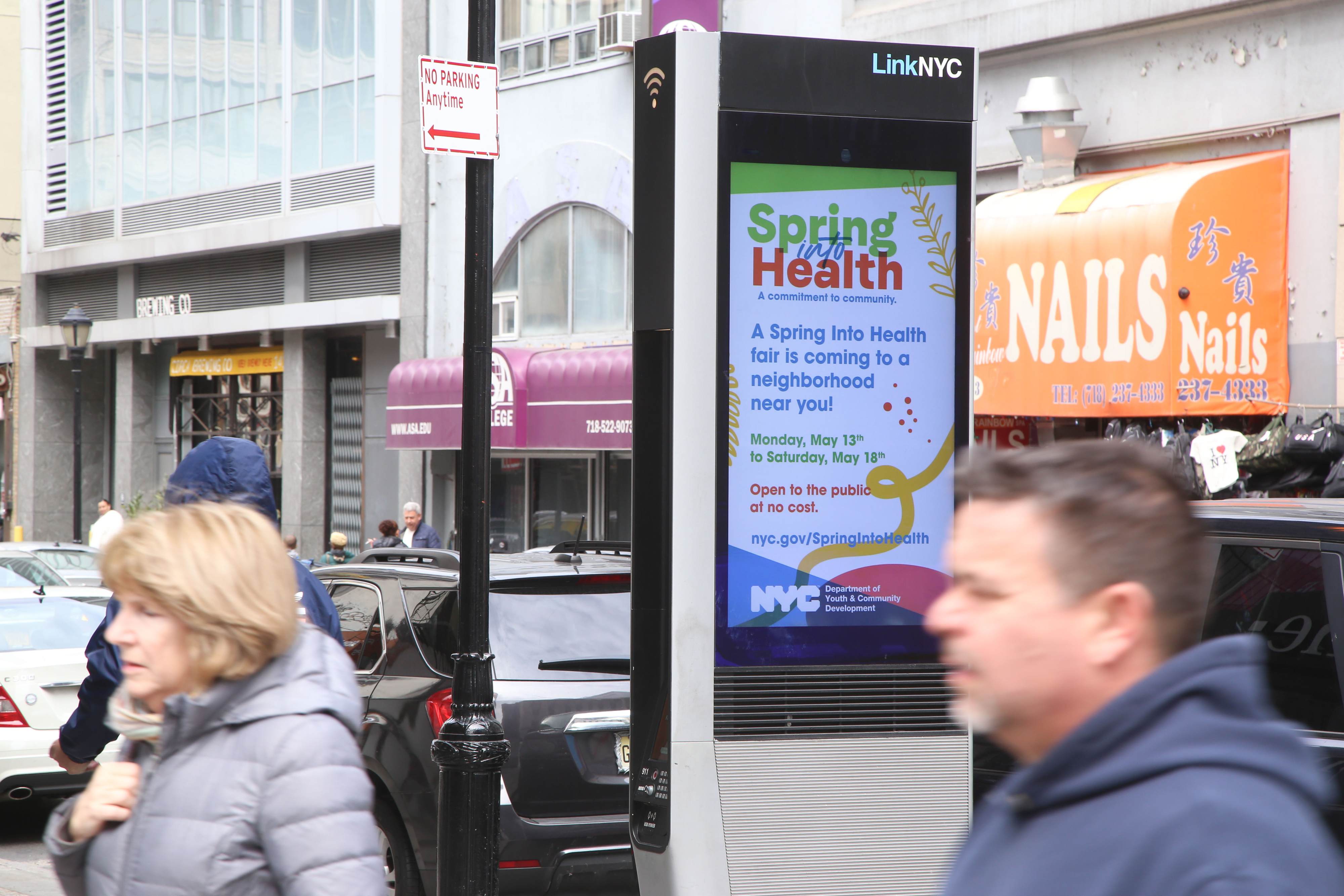 A LinkNYC kiosk displaying the DYCD Spring Into Health Fair advertisement.