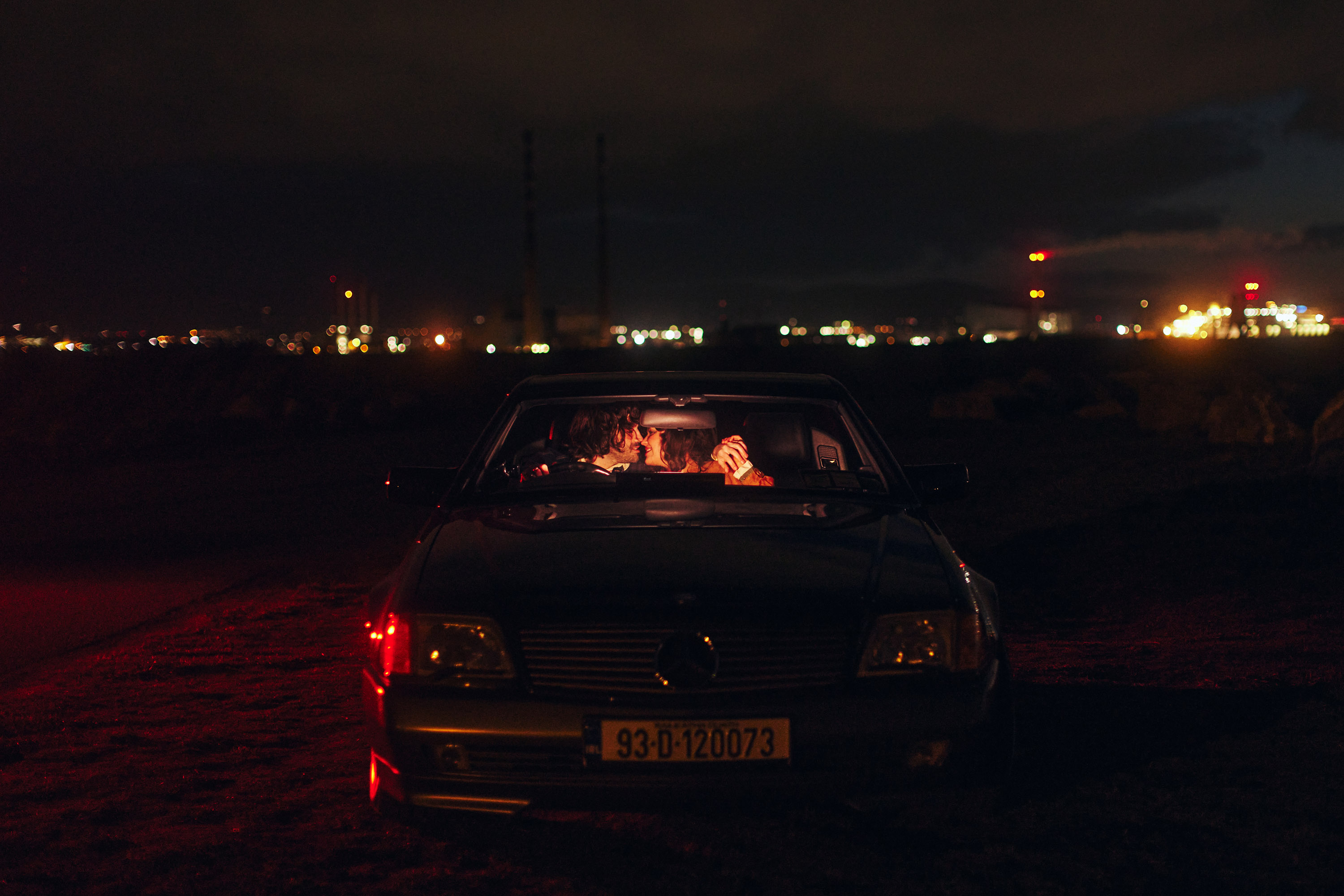 A story of young love in the suburbs told through photography, featuring stylish models in vintage clothing, photographed at sunset in Dublin, Ireland by fashion and lifestyle photographer Alex Sheridan. Suburban Love photo series. Featuring a vintage 1993 Mercedes Benz SL class and cinematic lighting and red light. Euphoria inspired photoshoot.