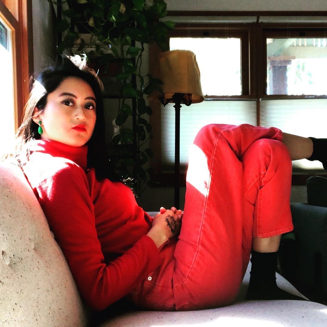 Bz in red at home in Tovaangar (what is currently called Los Angeles). Jade earrings from Los Angeles Chinatown.