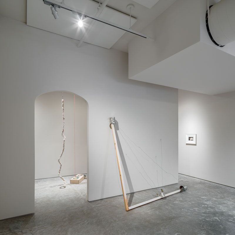  Installation shot, Other Hours, curated by Phoebe d'Heurle and Maryam Hoseini. From left to right: Gulsah Mursaloglu, Riegl’s Journey Through Hoops of Varying Sizes, 2017. Orange peels, orange, hand lotion, clay, porcelain and mixed media, dimensions variable. Al Taylor, Untitled, 1994. Tin cans, tin can lids, wood, wire, 84 5/8 x 91 3/8 x 32 1/4 inches. Luigi Ghirri, Bressanone, 1978. Silver Dye-Bleach Print (Cibachrome), 5 7/8 x 8 11/16 inches. (Credit: Rafael Gamo)