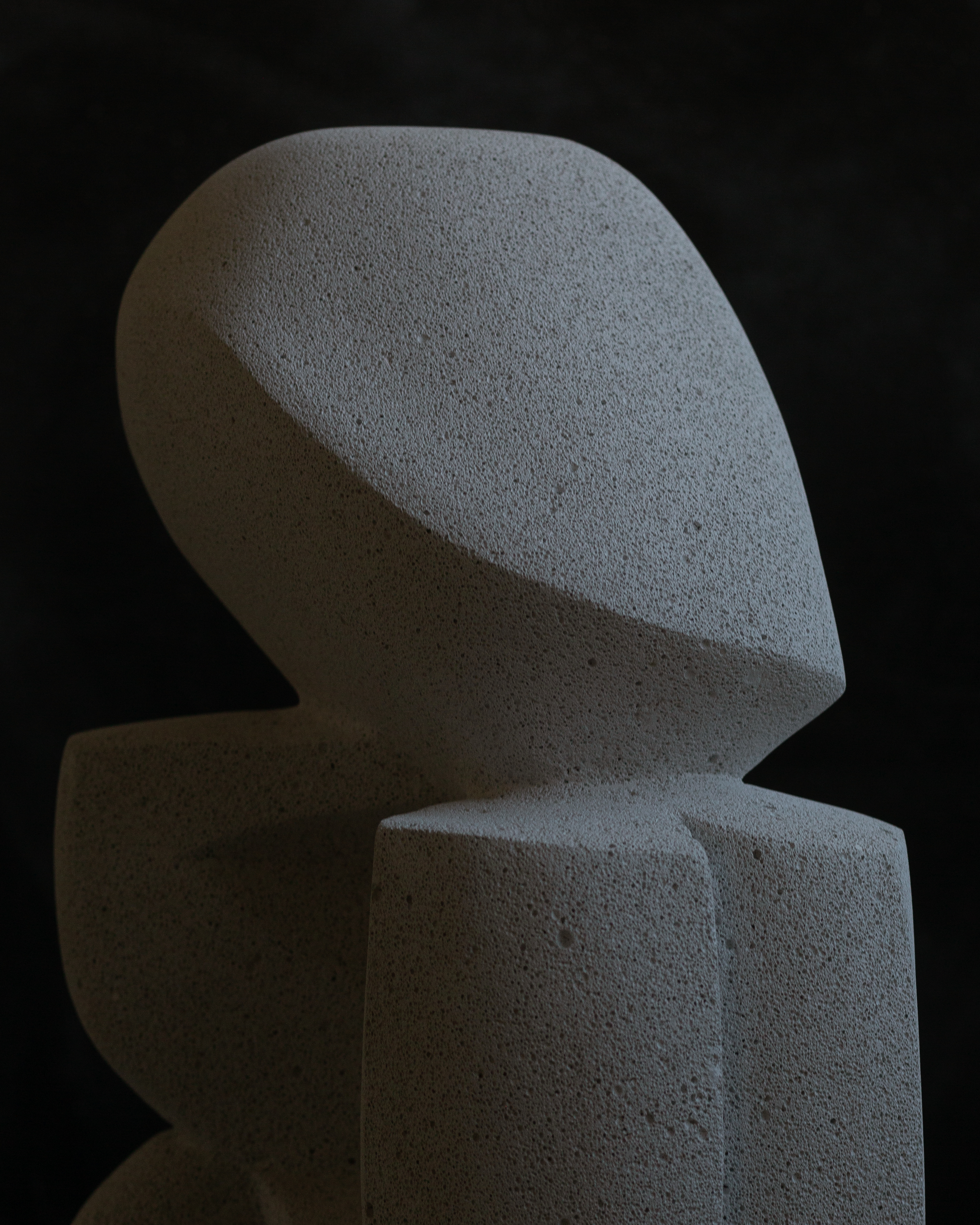 stone sculpture of abstract figure resting its head on its hand made by Benjamin Ewing artist