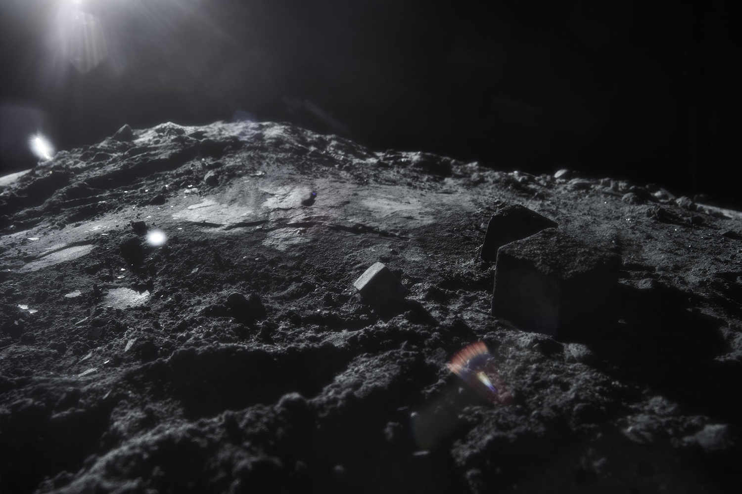 KMA photographer Daniel Schweizer photographs a shadowy shot of grey dirt and rocks with a black sky for HIGGS