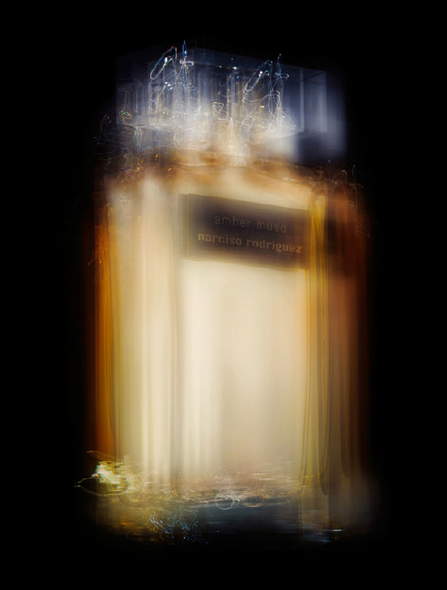 KMA stylist Sara Wacksman designs set for photo of blurry gold perfume bottle against black background for Numéro Magazine