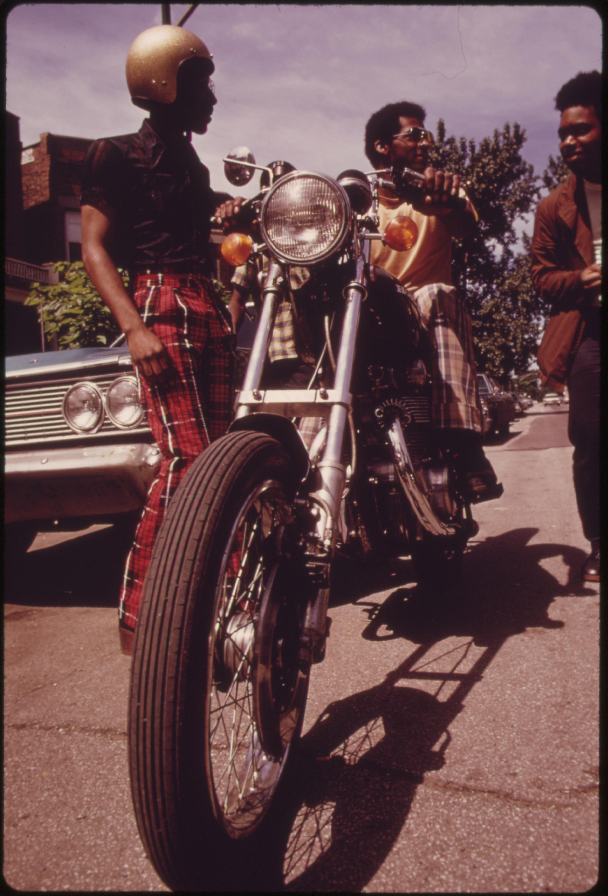 Black residents of Chicago's West Side check out a motorcycle. The city's West Side did not quickly recover from the riots and fires of the mid to late 1960s. According to the 1970 Census, some 22 to 29 percent of the area’s residents were below the official poverty line. A Black businessman’s group, with federal help, had signed agreements with several nationwide franchises that pumped $20 million in jobs into the community, June 1973.