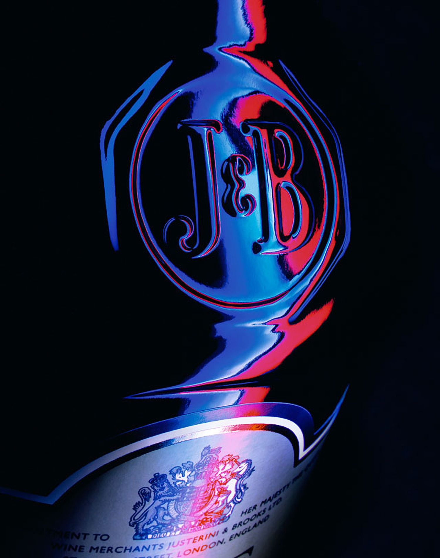 KMA photographer Daniel Schweizer photographs the Justerini & Brooks logo with blue and red lights with a black background