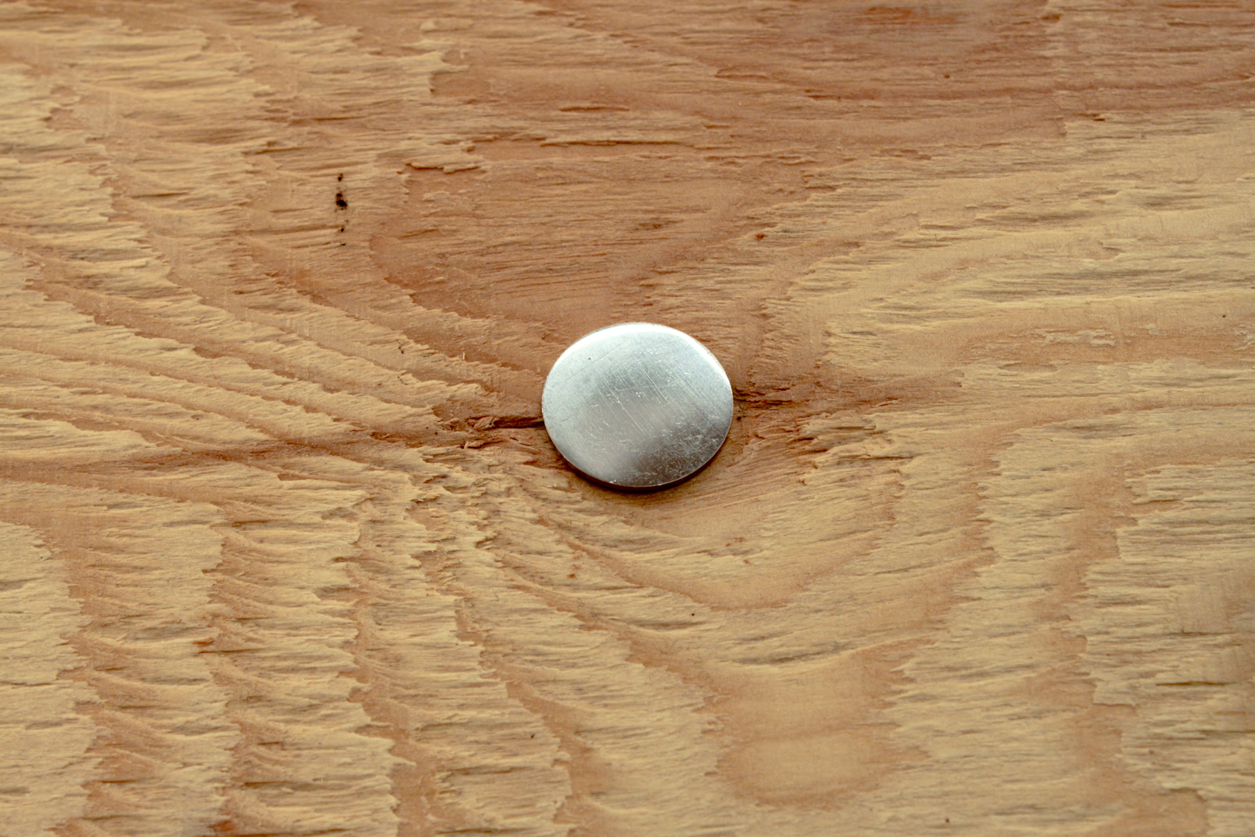 Infinite ullage, 2017, coins defaced to the point of becoming mirrors