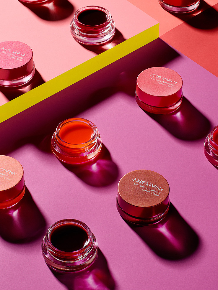 KMA stylist Rachel Haas designs set for photo of colorful lipglosses in their bottles on colorful background for Josie Maran