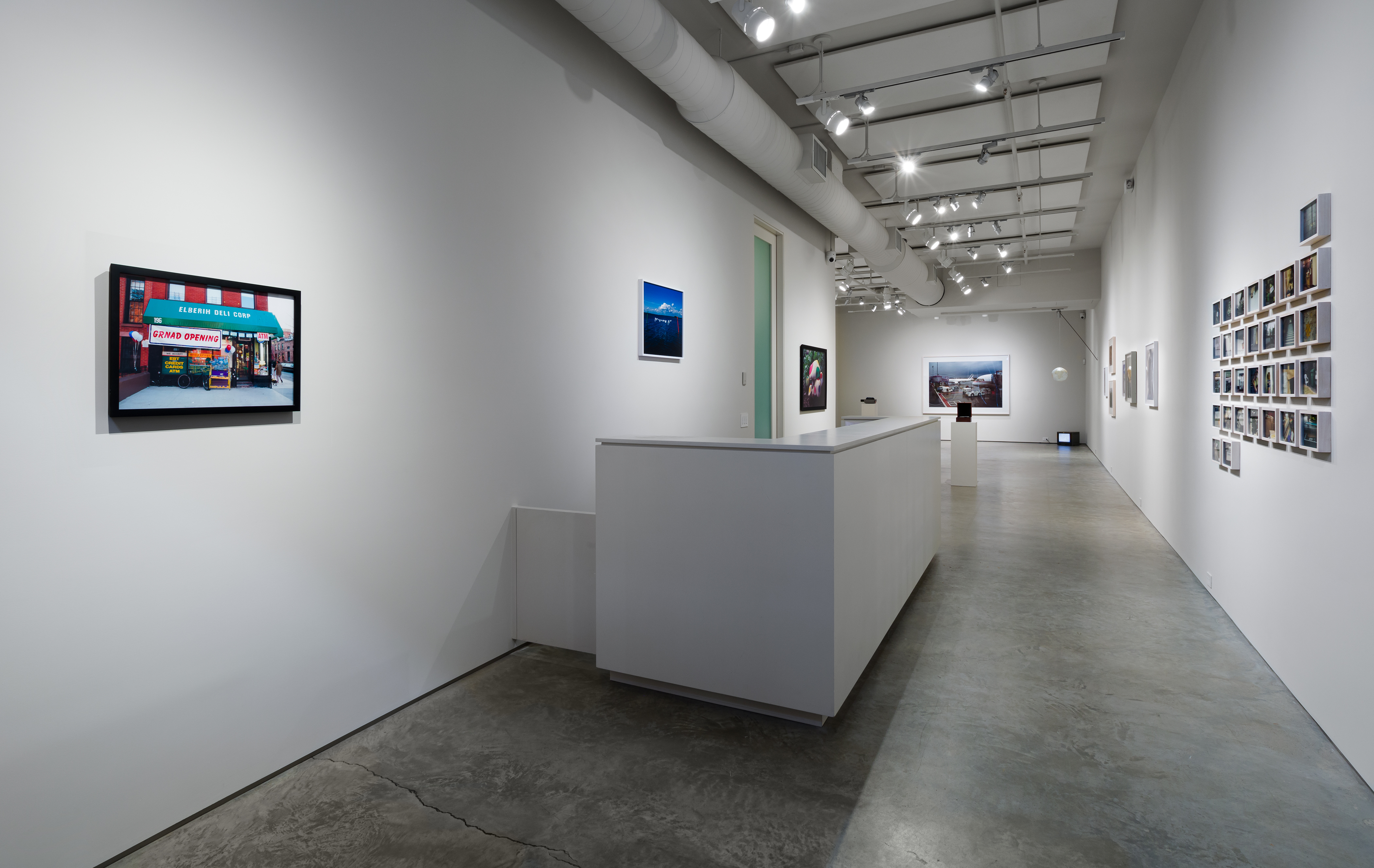 From left: Nina Katchadourian, "GRNAD OPENING," 2006, C-print, Edition of 5 + 1AP; edition 2/5, 16 x 20 inches. Nina Katchadourian, "Intimate Marine Signals," 2001, Digital C-print, Edition of 5 + 2AP; edition 3/5, 20 x 24 inches. On right wall: Rivane Neuenschwander, "London, December 2001," 2006, C-print in 31 parts, 5 1/2 x 8 1/4 inches each. 