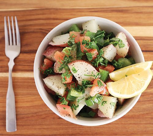 A delicious looking bowl of potato salad on wood table