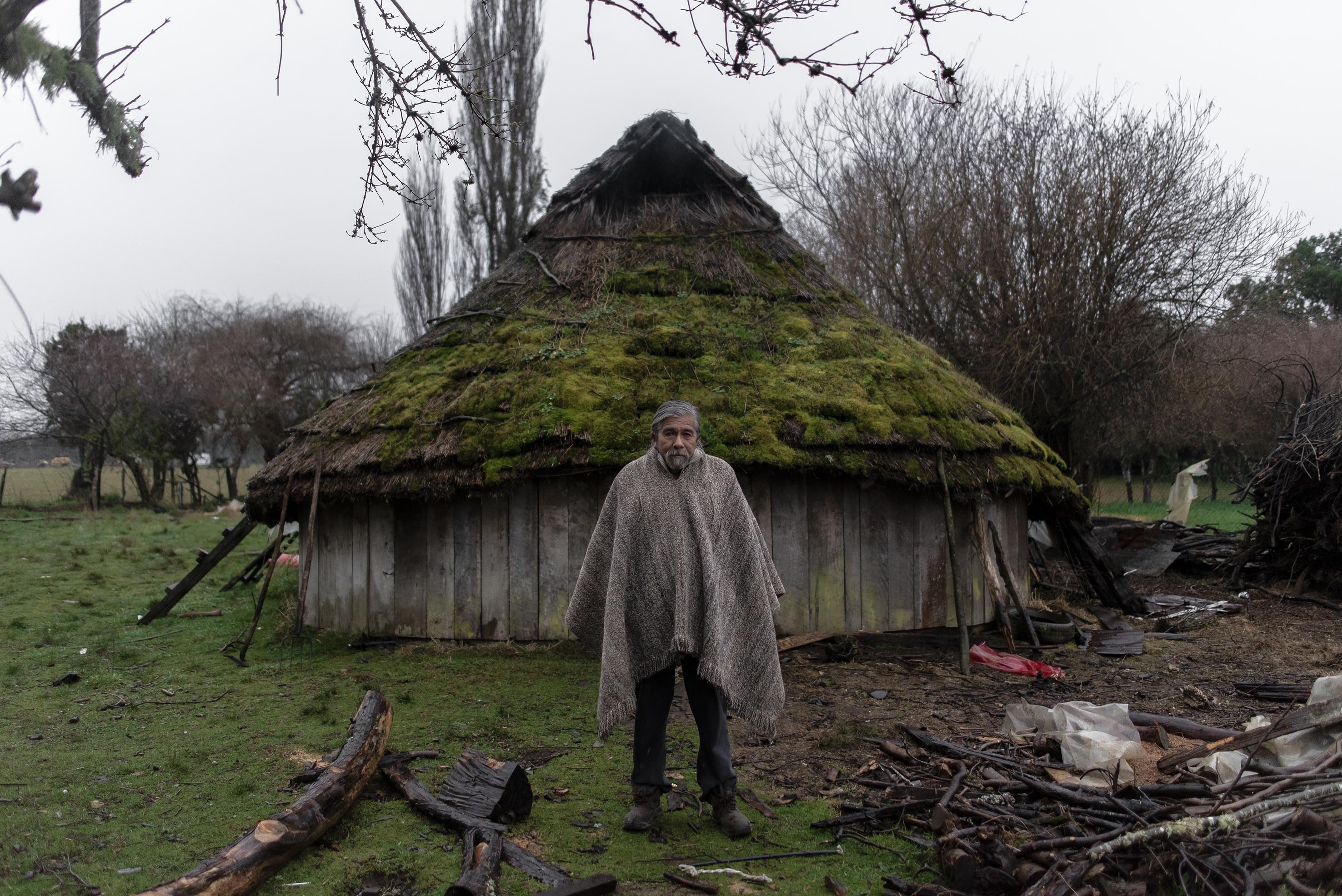 Leocadio Sánchez, "Lonko", in front of his Ruca. These traditional structures have served as a meeting place for members of the communities.