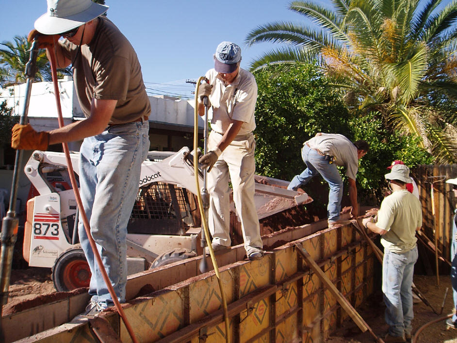 Rammed Earth Construction A specially prepared mix of earth is poured damp into a form and tamped or rammed. The compression creates a durable monolithic wall with a texture like sandstone which can stand unfinished for hundreds of years. The mix can be natural or stabilized by adding pozzolans or cement as binding agents. Tapial usually refers to the older practice of forming the wall in small sections. Modern rammed earth often utilizes large forms and machinery for mixing, placing, and tamping.
