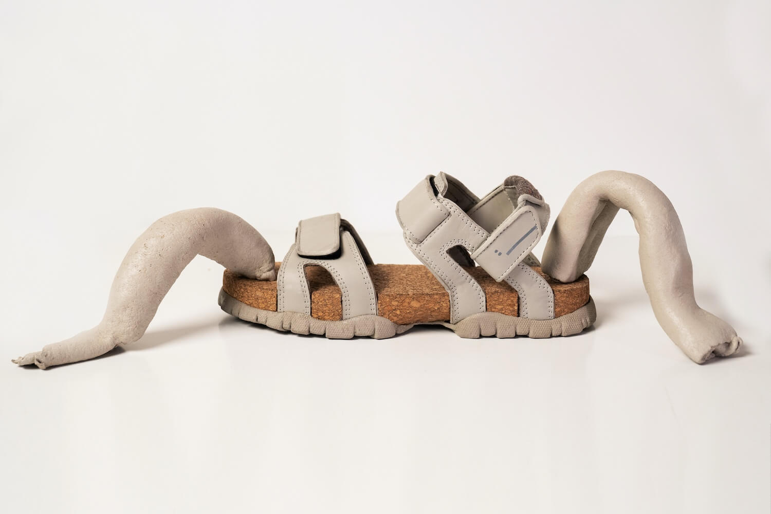 A grey sandal with a sole made from natural material