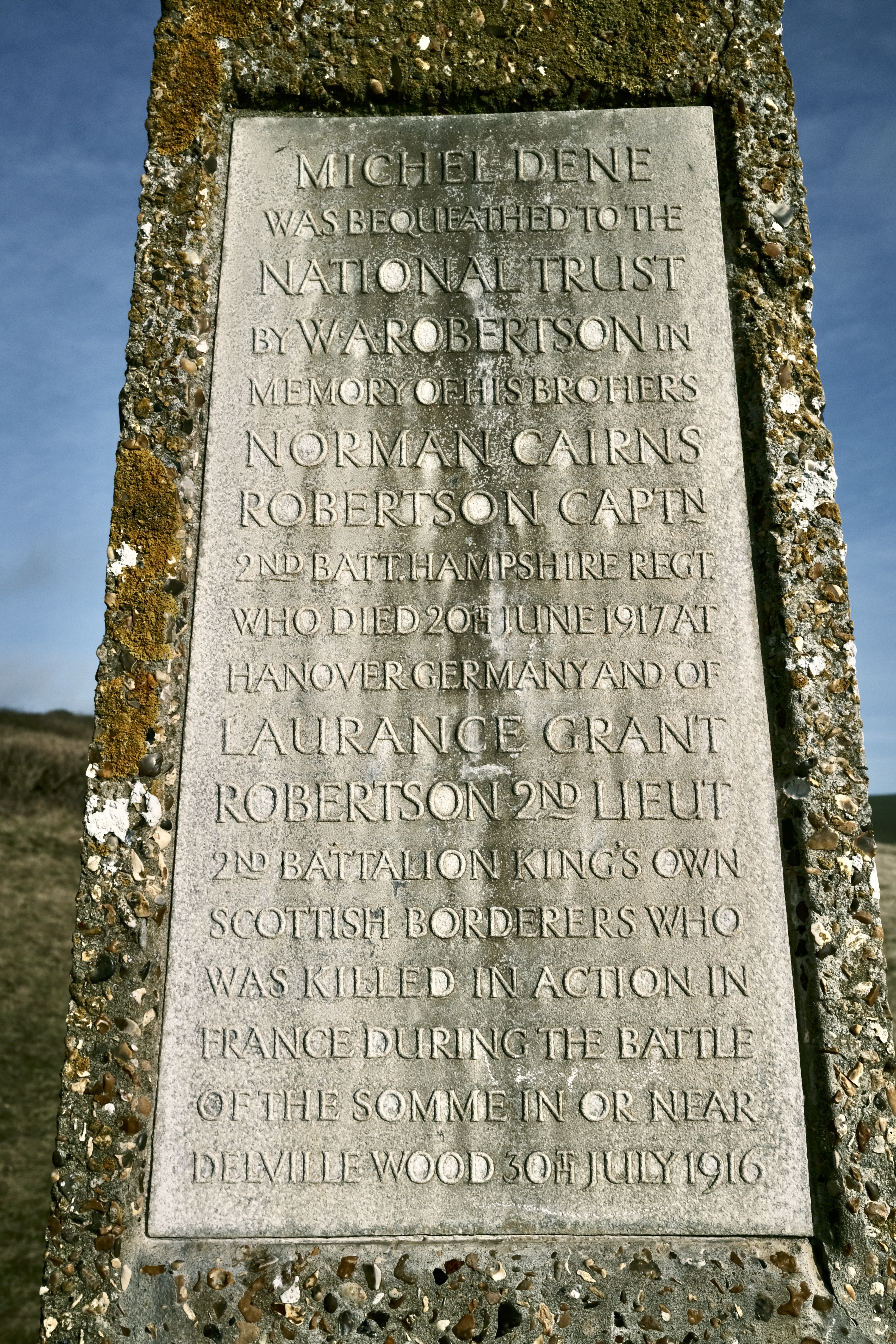 A stone tablet in a embedded in a large rock pillar. The embossed text reads: “Michel Dene was bequeathed to the national trust by W A Robertson in memory of his brothers Norman Cairns Robertson Captn 2nd Batt. Hampshire Regt. Who died 20 June 1917 at Hanover Germany and of Laurence Grant Robertson 2nd Liuet 2nd Battalion King’s Own Scottish Borders who was killed in action in France during the battle of the Somme or near Deville Wood 30th July 1916.