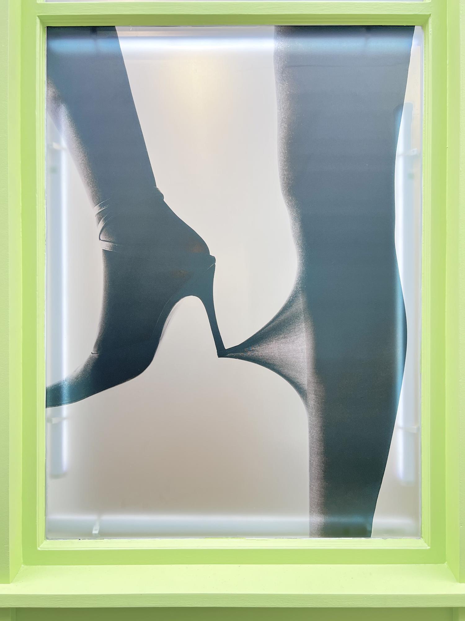 Sheertex campaign window graphic showing black high heels stretching rip-resistant tights.