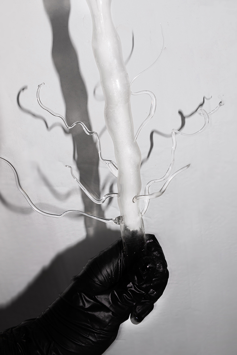 Detail of Pyrosoma Atlanticum (Rodillo de Fuego) Lamp made with blown glass from Plaja Studio hold with a hand