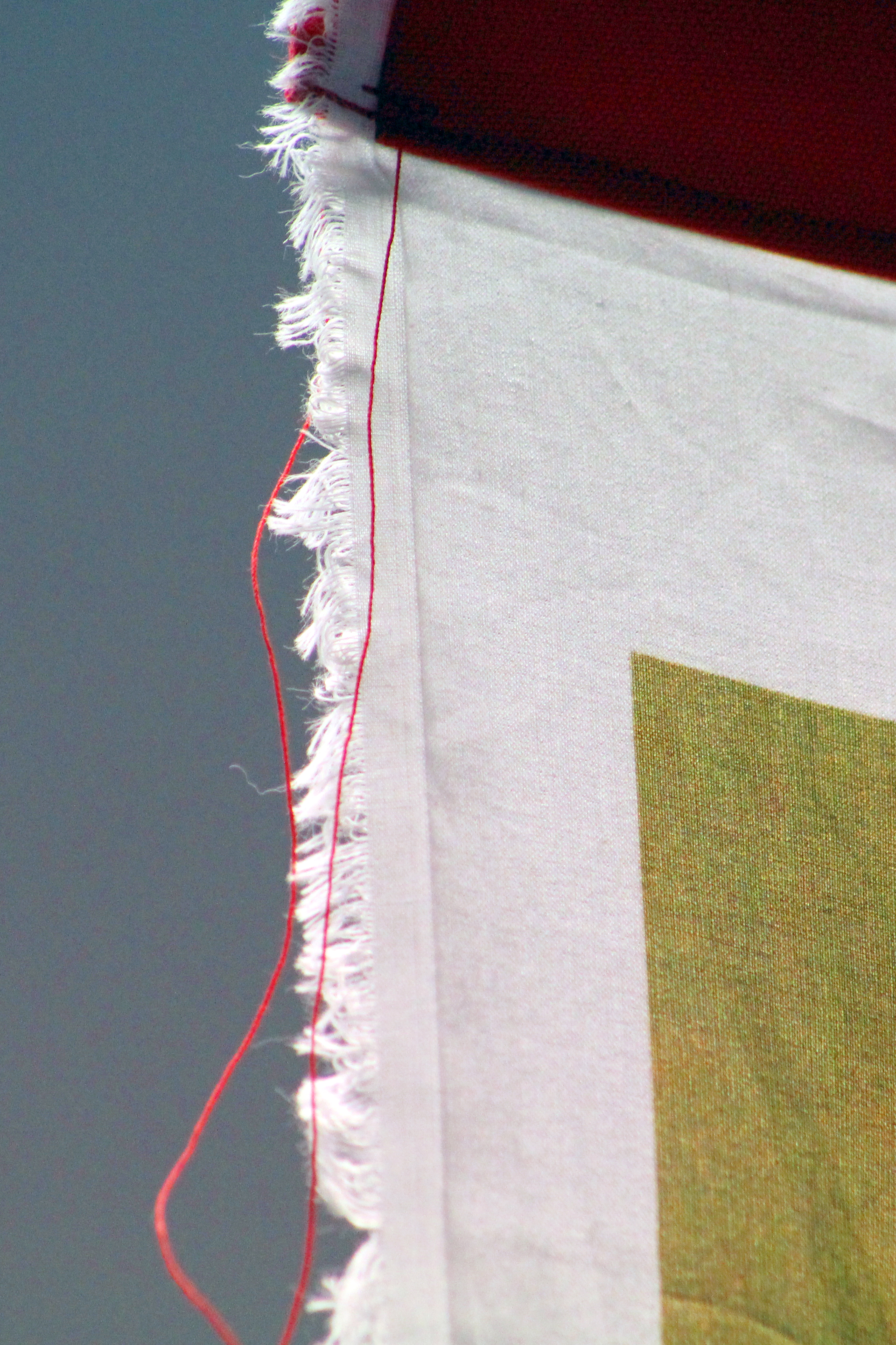 Raw edges and stitching highlight the woman's work