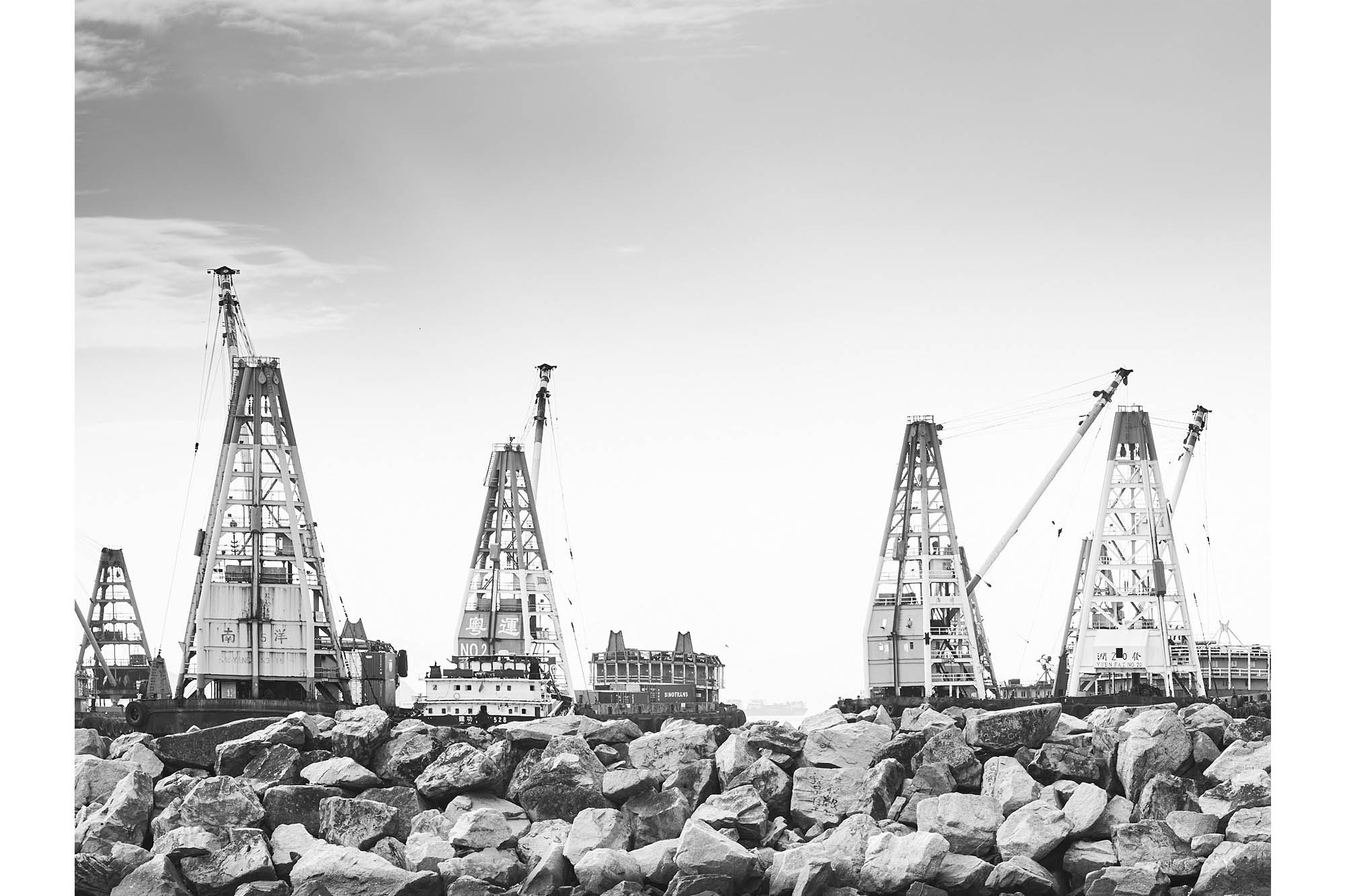Floating ship loading cranes near breakwater rocks, Hong Kong Harbour
