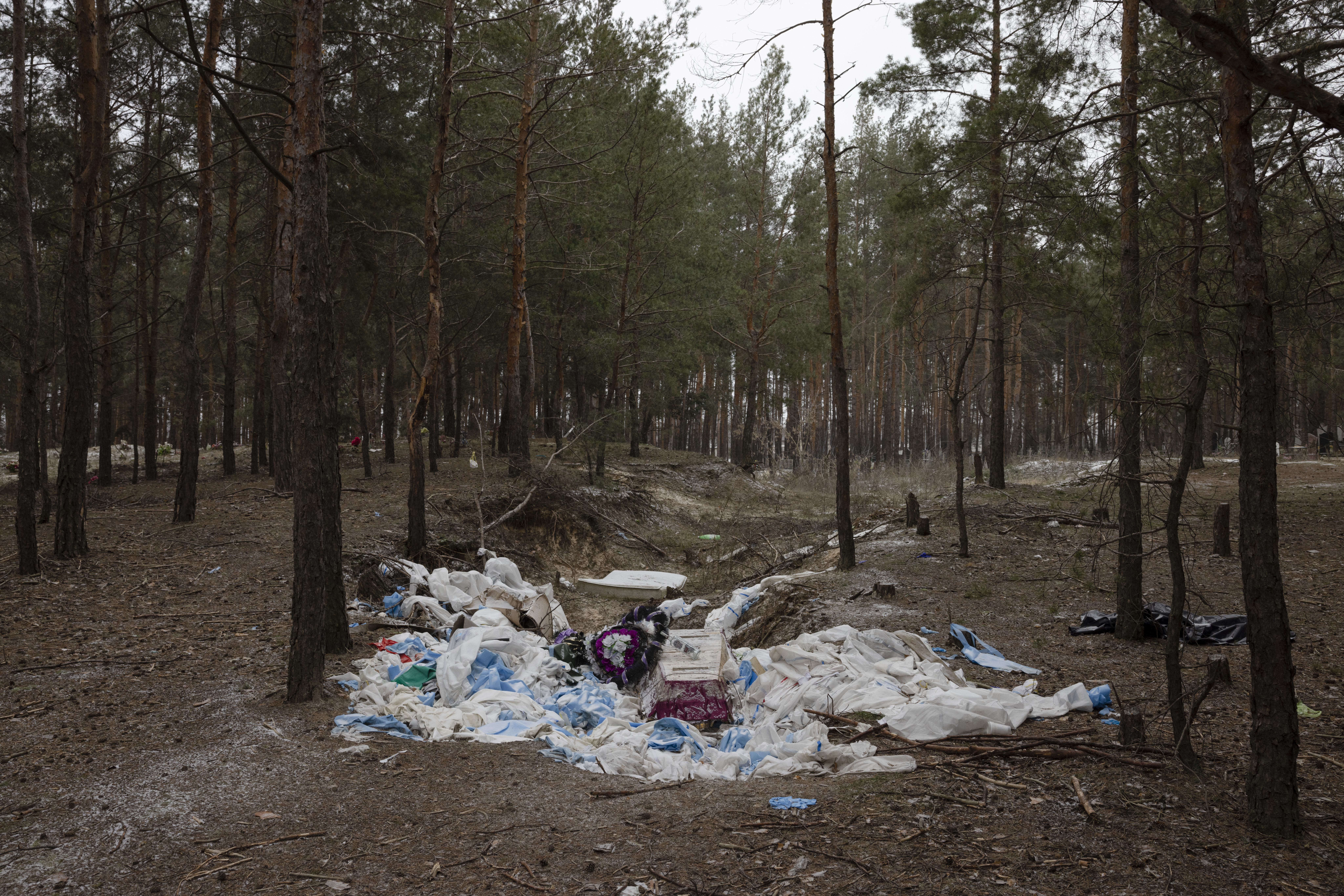 A mass burial site in Izium that was in September 2022 a media hotspot for a couple of weeks, had by January 2023 turned into a landfill of hazmat suits. About half of the bodies that were dug out from the site were still not identified and more bodies had also been found around the city. On the grave site the silence of the now forgotten scene was interrupted occasionally by explosions of demining happening in distance.
