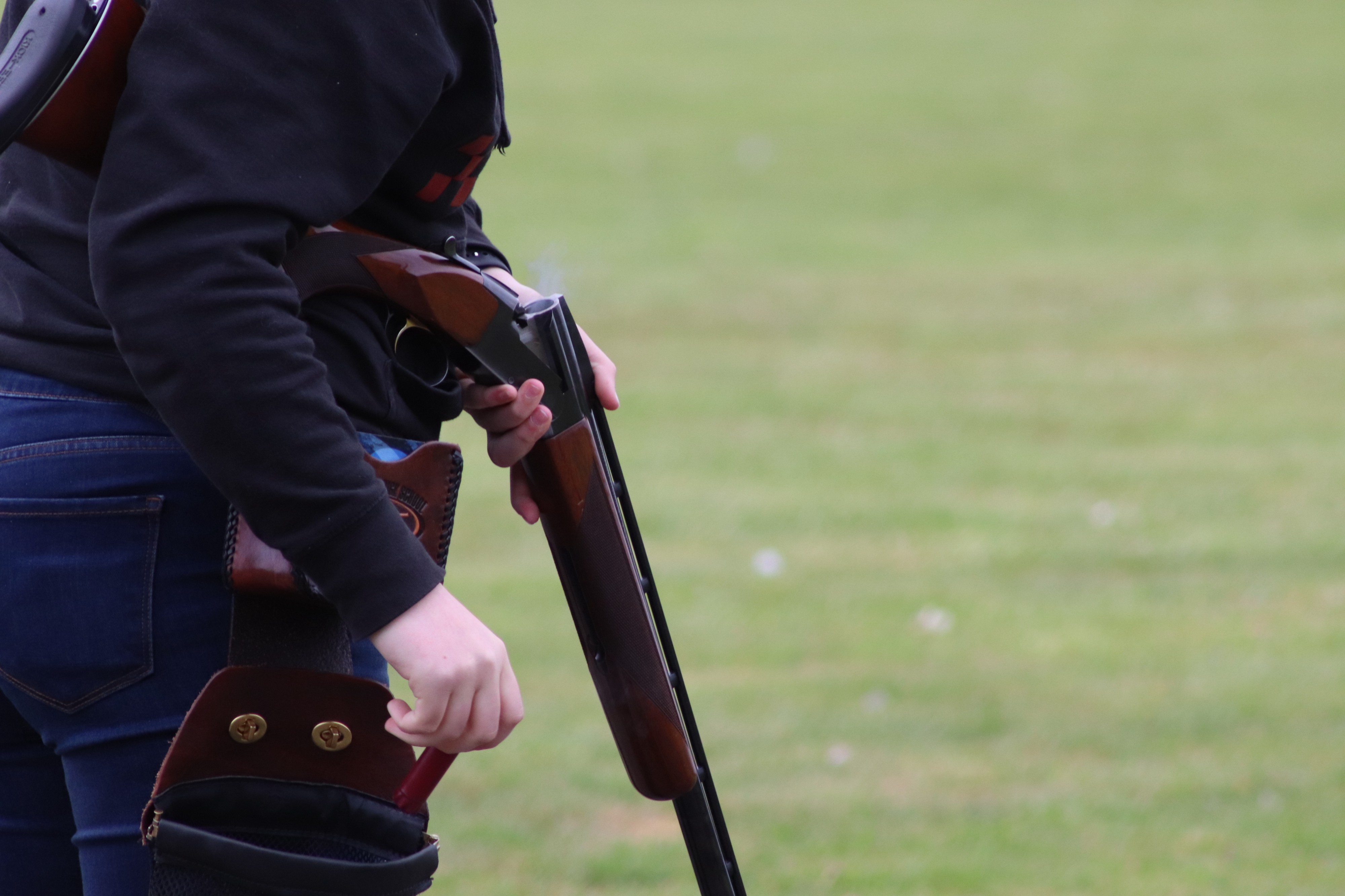 Charlotte Phillips shoots and collects her empty shells in a bag on her hip for later reloading.