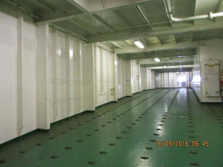 A hallway photo from inside the Atlantic Conveyor. The metal walls are white and the metal floor is green and covered in latches. The time stamp reads: "16/09/2016 06:45"