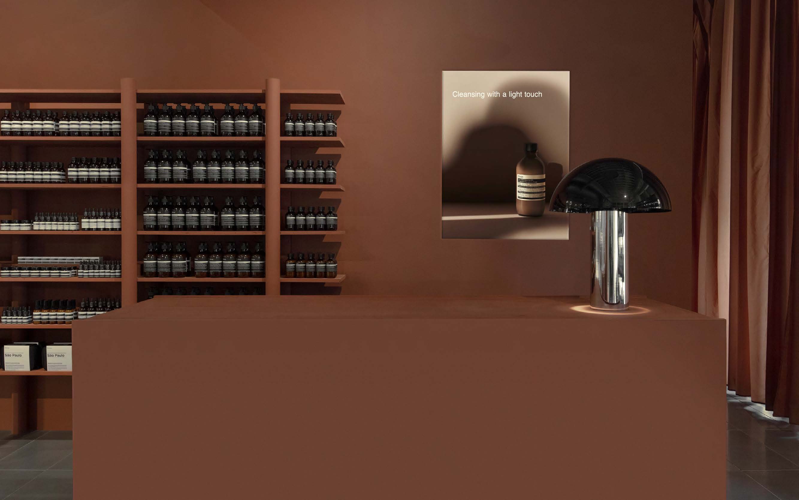A campaign poster in situ within a store. A POS is in the foreground and product shelving is in the background.