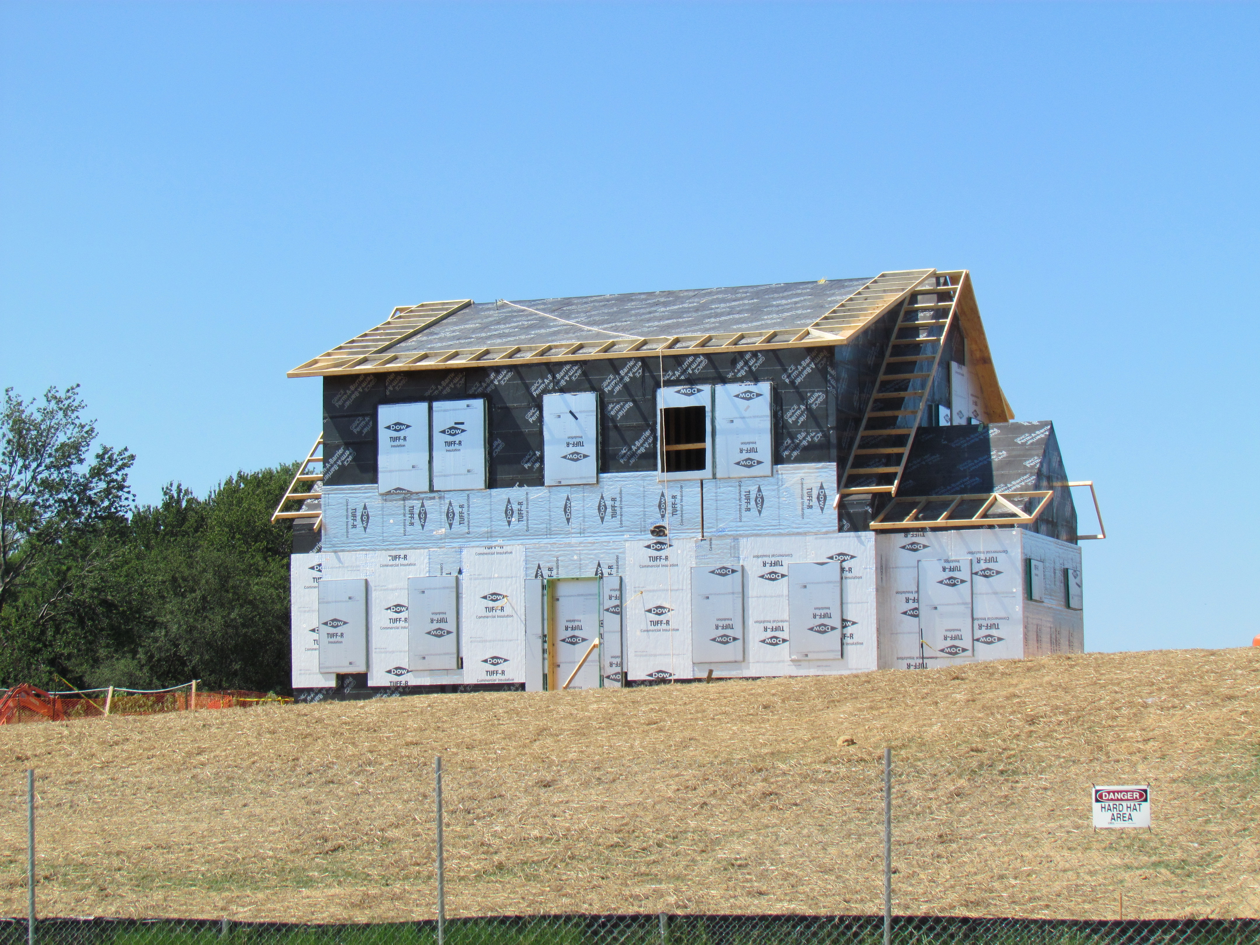 The advanced wall system of NZERTF's outer shell includes continuous foil-faced polyisocyanurate insulation on the home's exterior walls and roof. This "beyond code" insulating process boosts the home's energy efficiency, creating a tigher structure that maintains internal temperatures longer and shields the interior from outside elements.