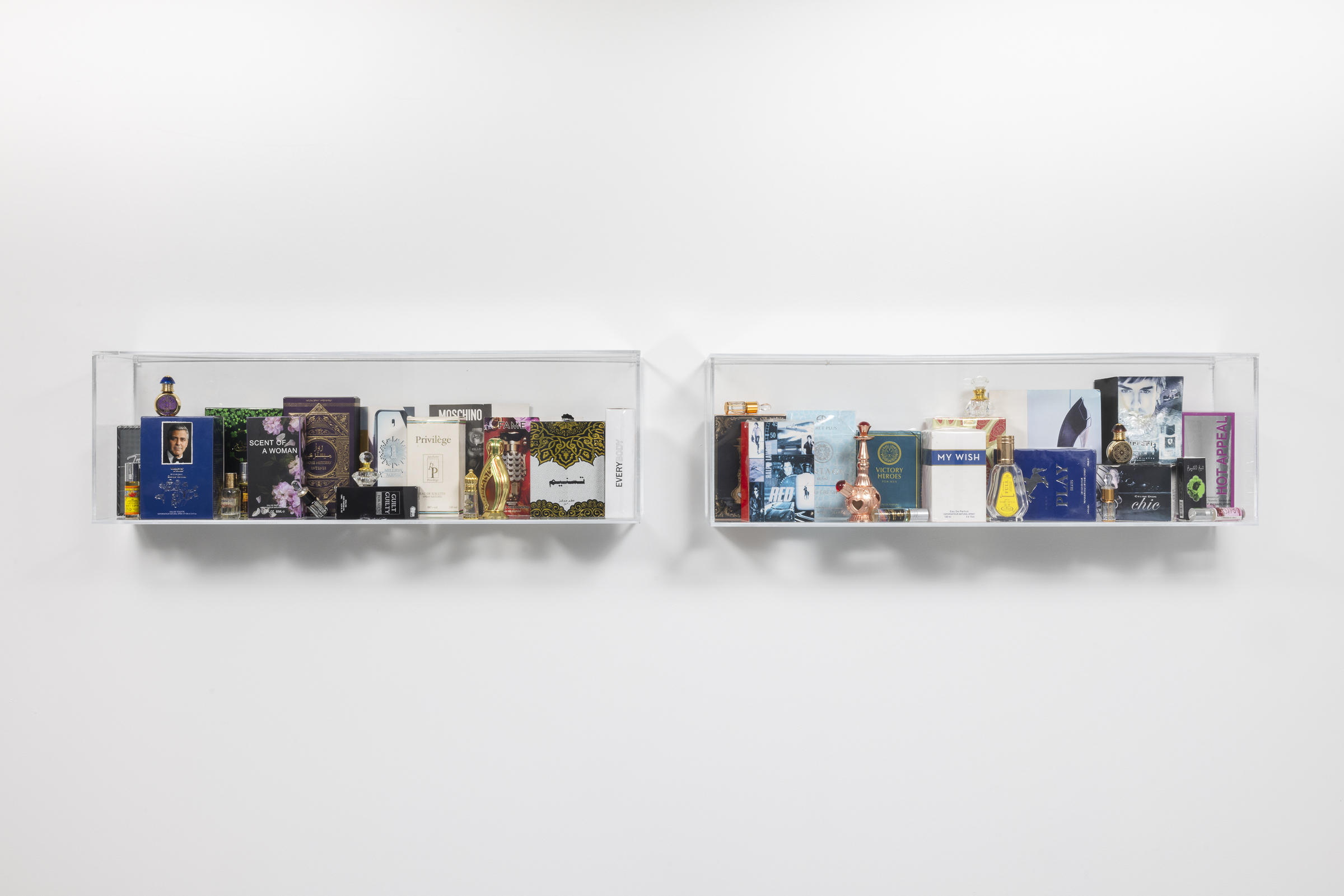 Moral Odor, 2025. Glass bottles, perfume and perfume boxes in acrylic display shelf, 9 x 60 x 6 in, 22.9 x 152.4 x 15.2 cm. Photo: Chris Uhren