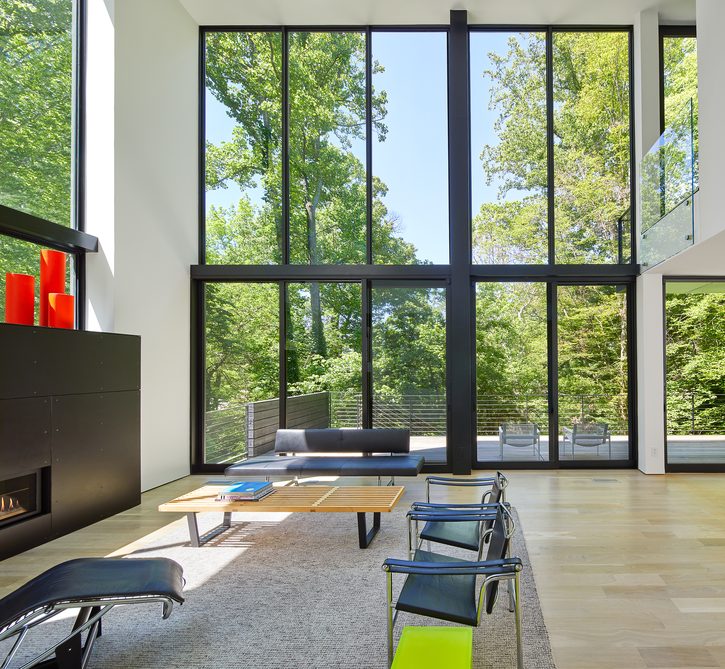 The living space is a two-story volume with large windows and access to the outdoors