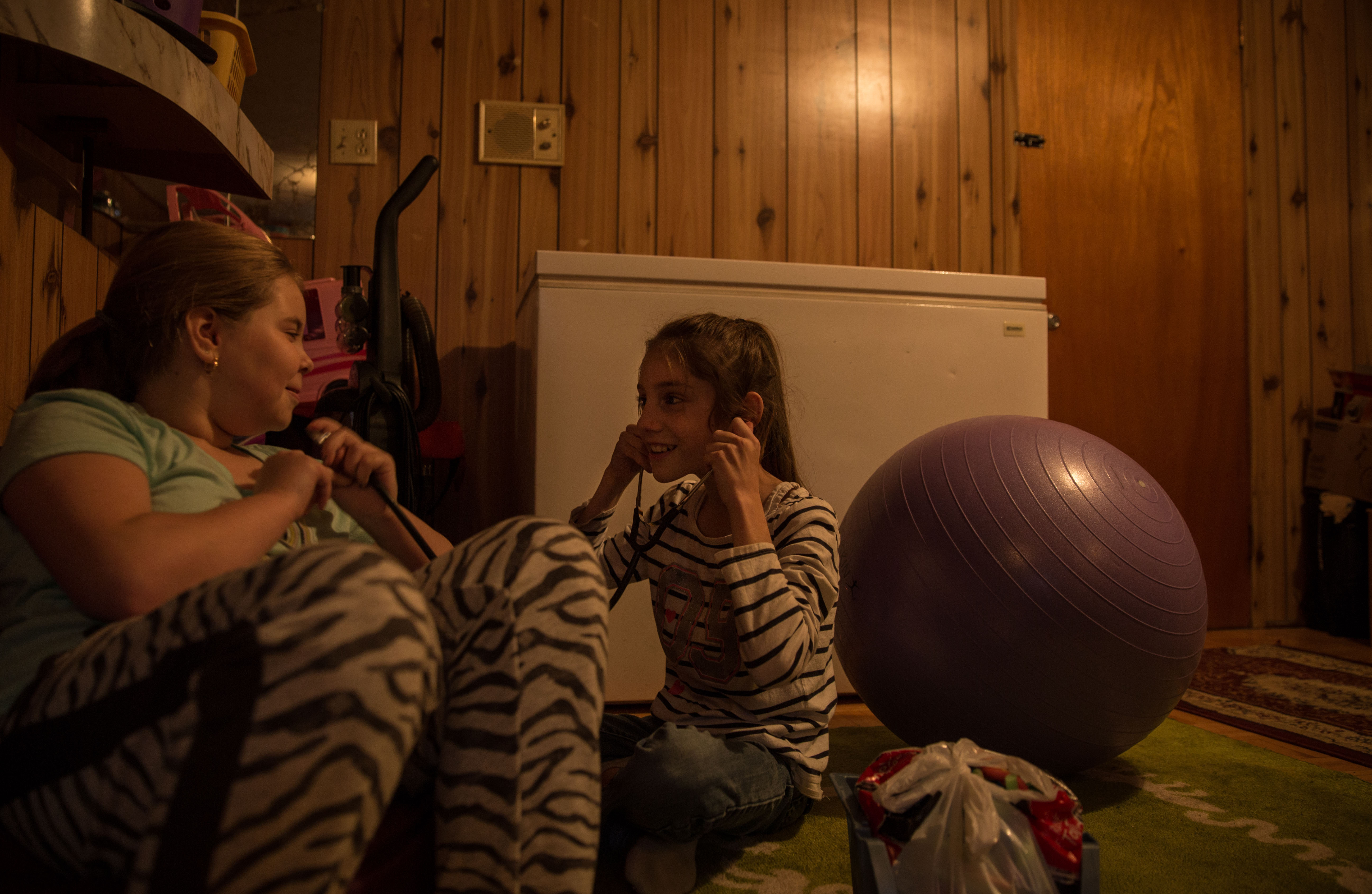 Paige Legresley (left) and Leila Bourcier (right) listen to eachother's heartbeats on a stethoscope in Paige's basement in Lasalle on Dec. 4, 2016.