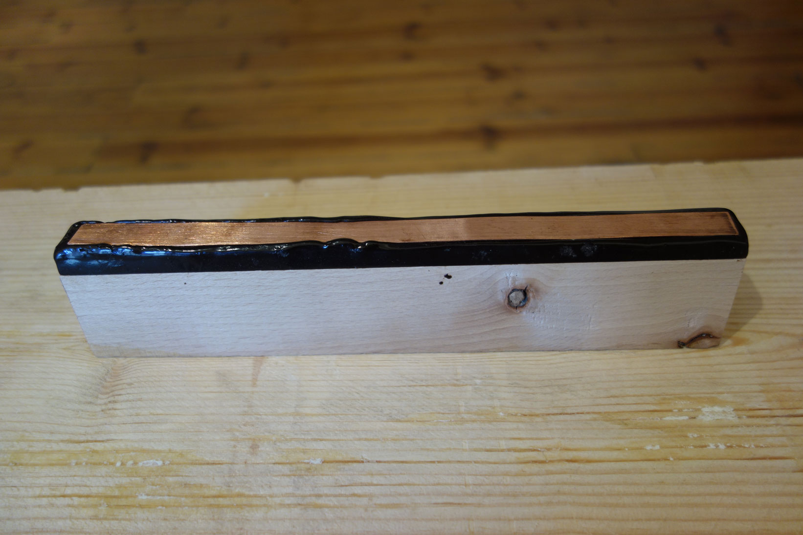 Untitled, 2018, wooden block, chasers pitch, copper plate, 26 x 3,5 x 5,3 cm