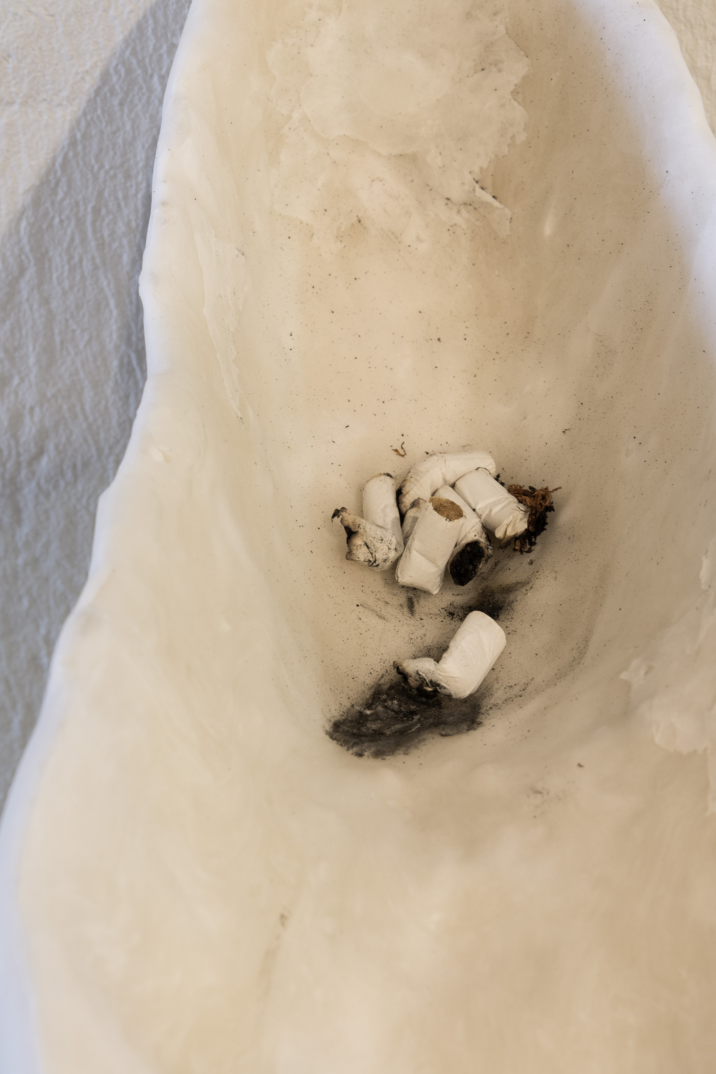 Bystanders (Public Ashtray), 2026. Acrylic One resin, air-dry porcelain, cigarettes and rubbish added by the passerby (outdoor installation). Various dimensions.