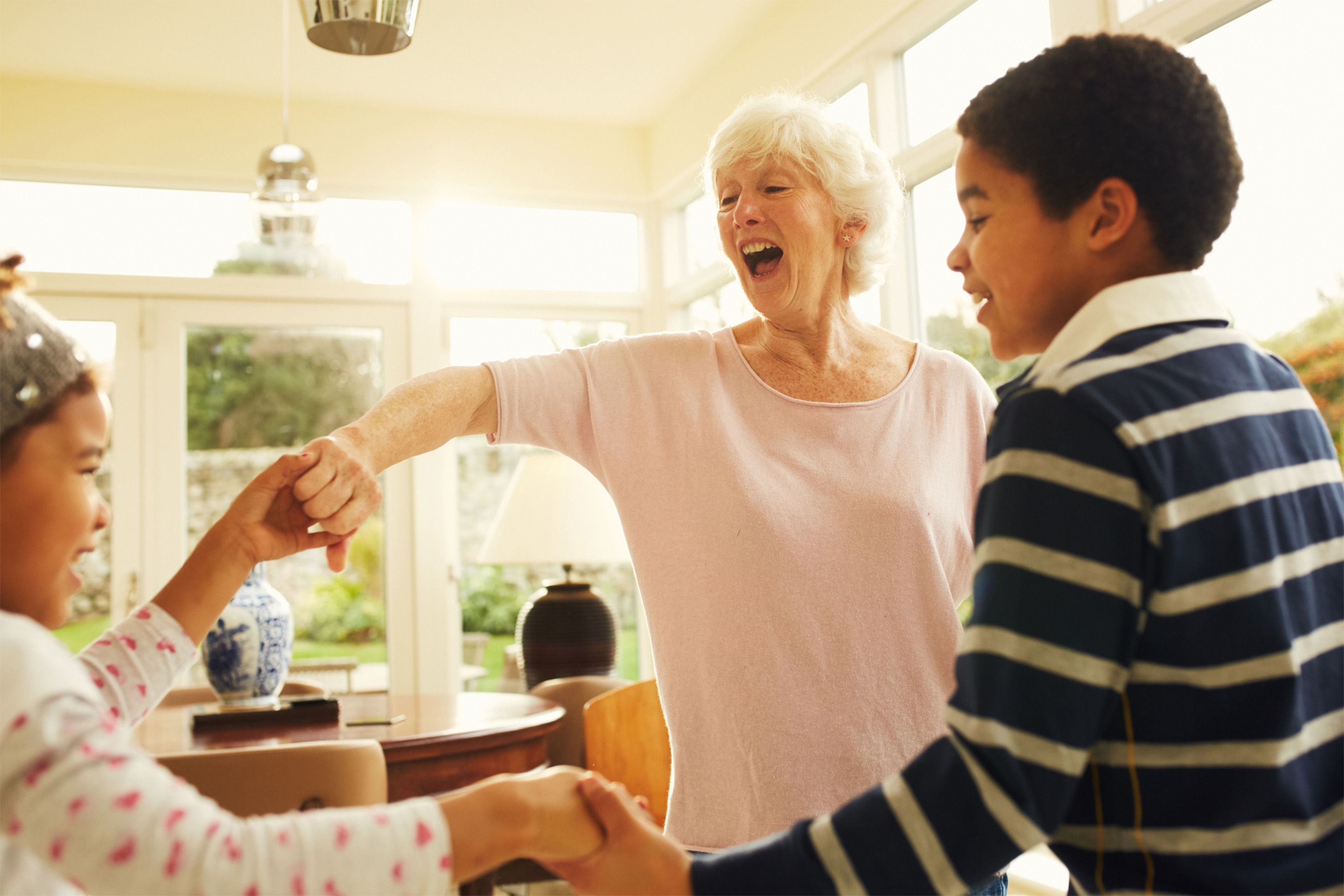 Lifestyle photo of grandmother dancing with grandchildren at home, photographed by Dublin based lifestyle, fashion, and advertising photographer Alex Sheridan for, capturing authentic energy and real moments