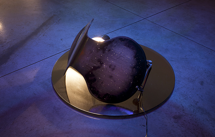 Casandra / 2013 - 14 / Perforated and burnt chair, lamp, lighting, mirror and directional speaker. The sound piece is a vocal piece executed by the sound artist Bárbara Lázara, creating a moan based on the waves, progressively blurred into a series of gestures and vocal sounds, articulating a growing lament, a soundscape that is rearticulated between the silence and the intensity / Dimensions vary / Audio: 15 min 