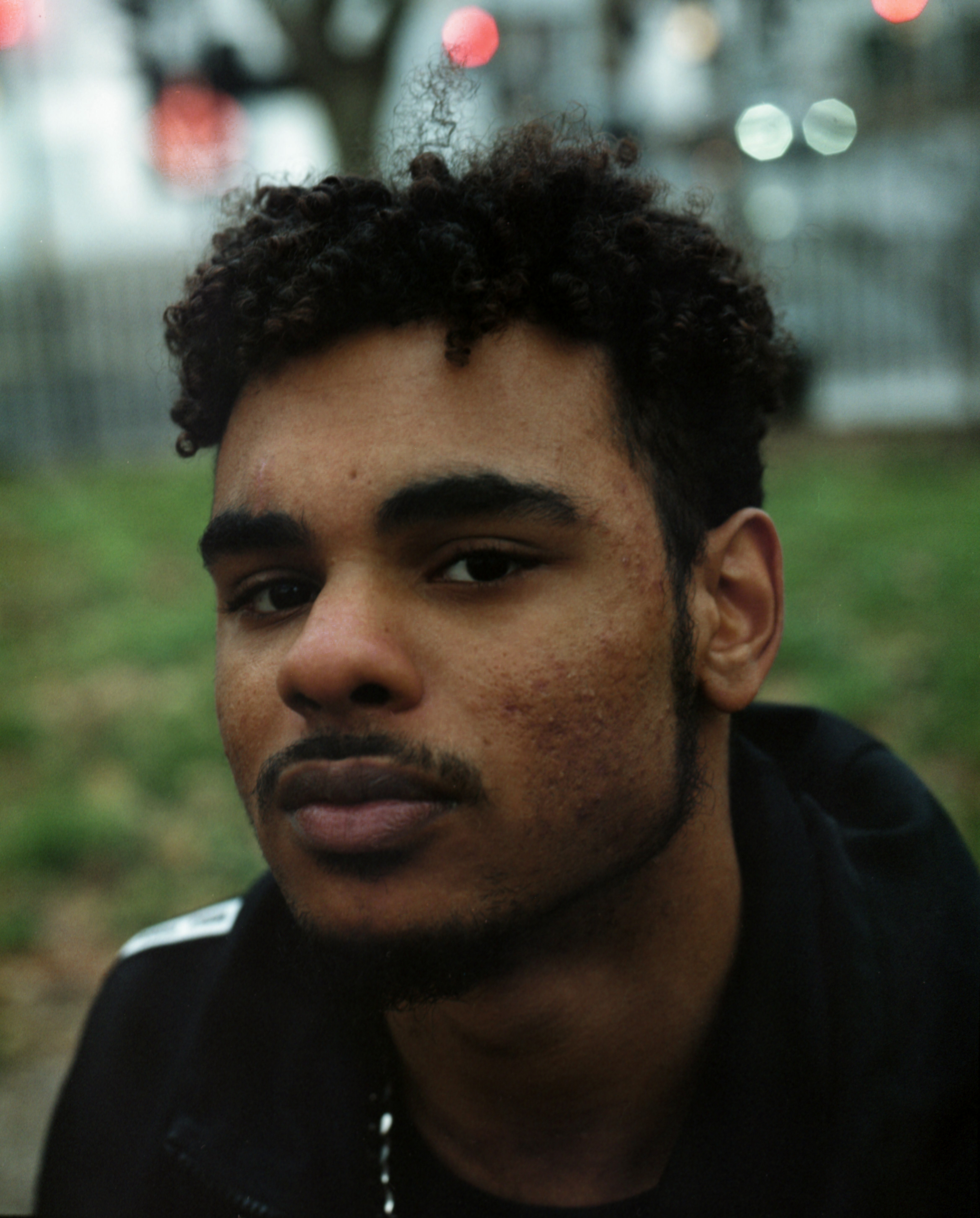 Portrait of a man with curly hair. He looks slightly from the left