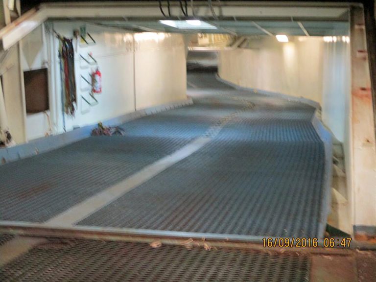 A blurry photo of inside the Atlantic Conveyor, we see a long winding hallway with white metal walls and a grated metal floor. The time stamp reads: "16/09/2016 06:47"