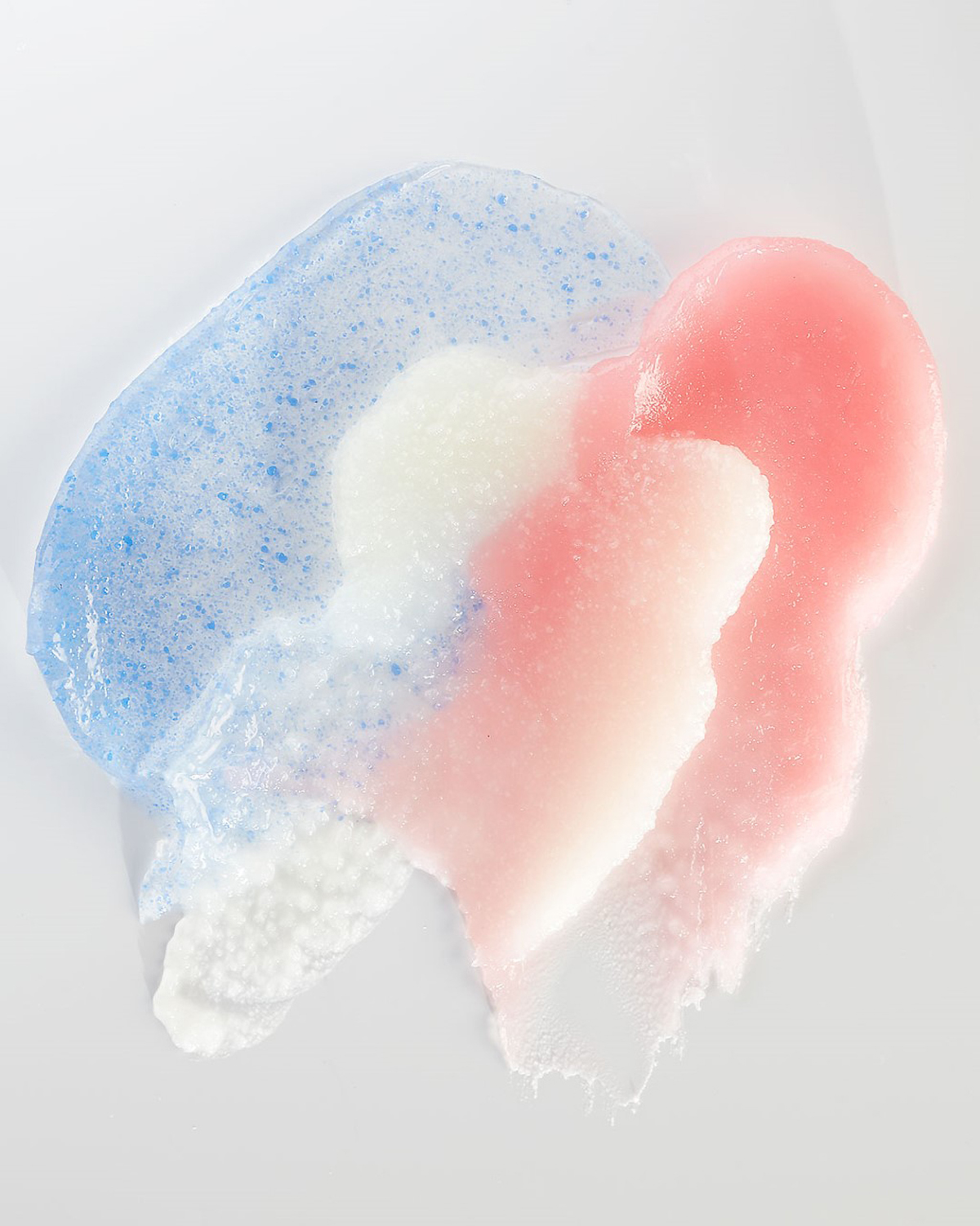 KMA photographer Vincent Gapaillard takes a texture photo of blue and pink gritty substances smeared on a white background