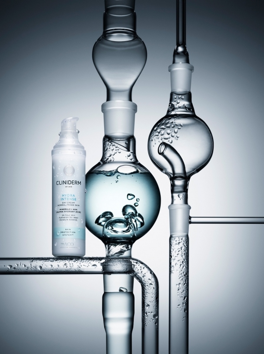 KMA photographer Mattias Nyhlin photographs white moisturizer bottle with glass bottles with a grey background for Cliniderm  