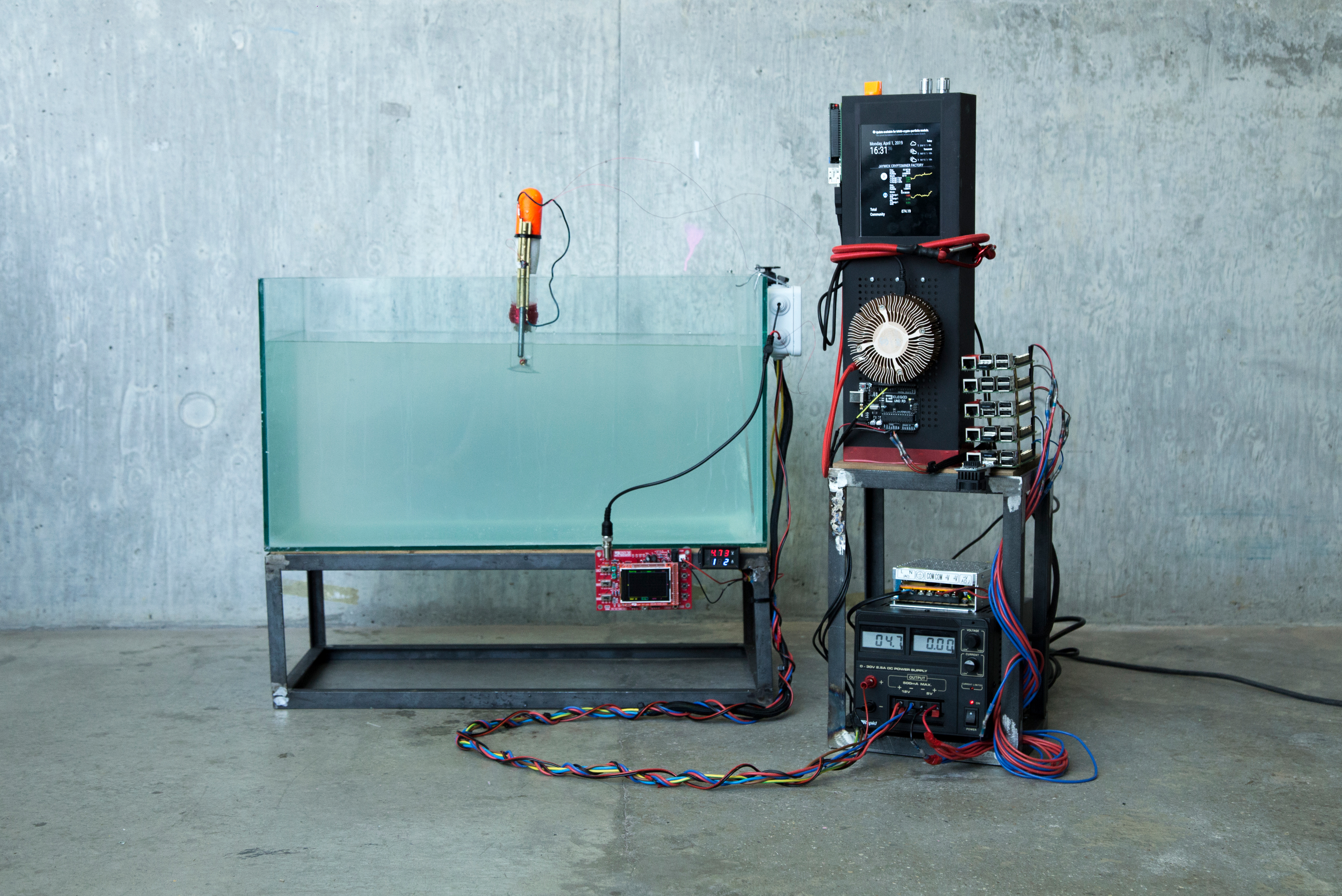 A water tank with an electronic device inside collecting energy. A machine with six mini-computer connected to it on the side of the water tank