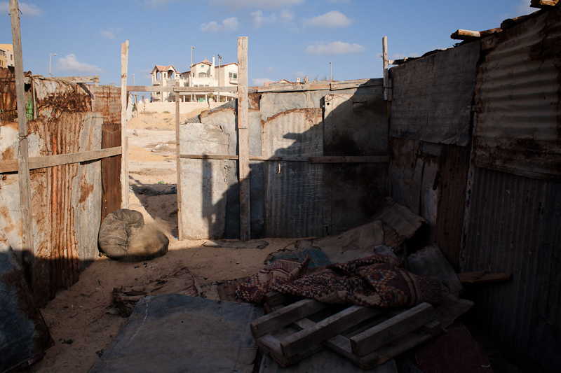 Gaza City, août 2012. Les cahutes des pêcheurs sur la côte gênent les projets des promoteurs immobiliers qui aimeraient les récupérer pour y construire des hôtels ou des villas comme celle en arrière-plan, qui se serait vendue dit-on autour d'un million de dollars.