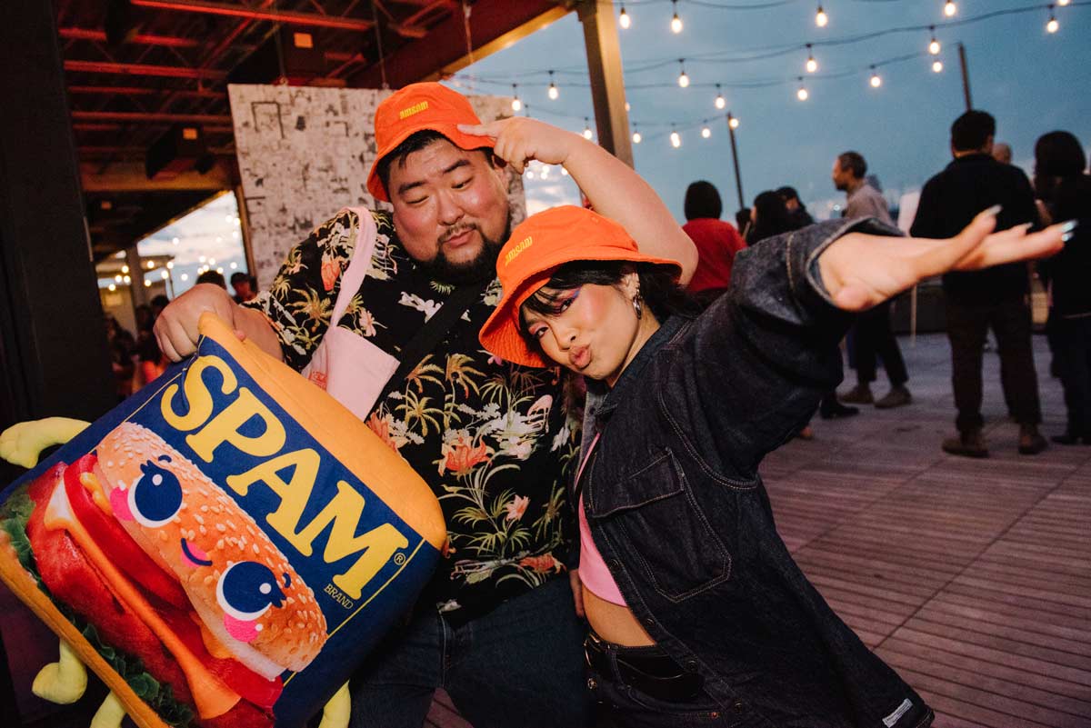 2 people posing with SPAM plushie