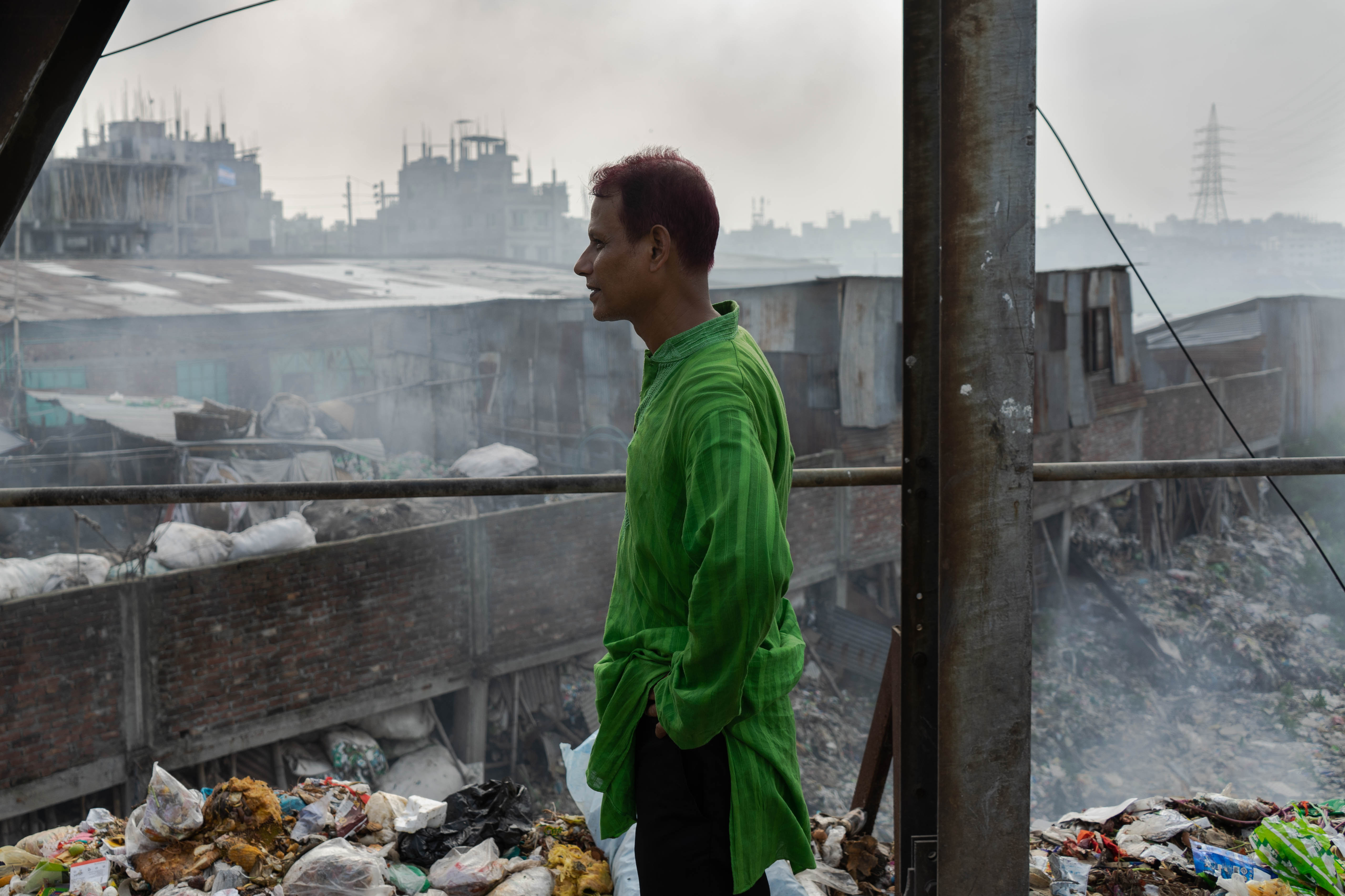 Shamsul Palash, an environmentalist from Dhaka, looks out over burning garbage in Kamrangirchar. He notes that 20 years ago this area was farmland. Now, he estimates one would have to dig for ten meters through garbage before reaching the soil.