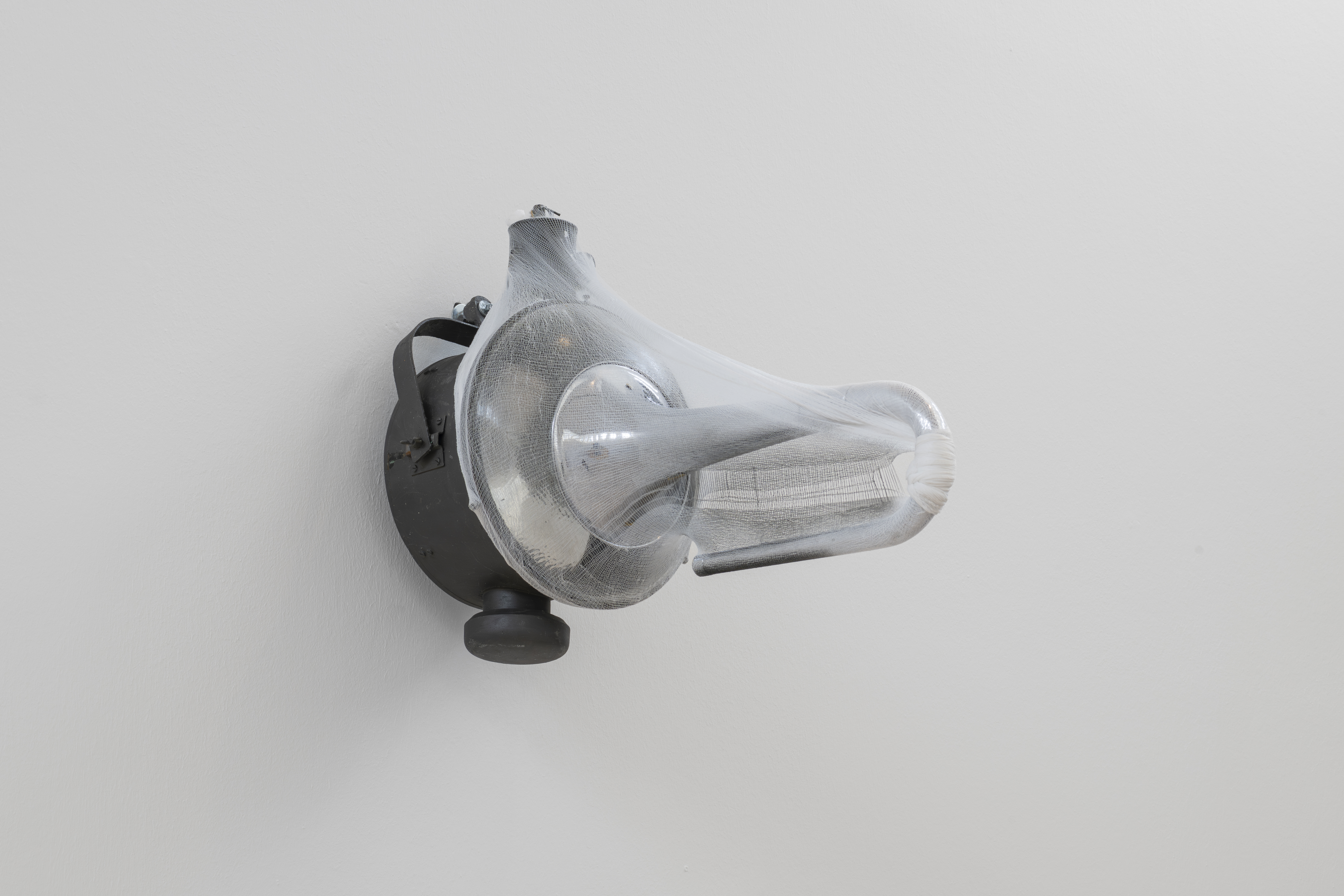 Finitudes, 2025, industrial street lamp, euphonium horn, stockinette, spray paint.