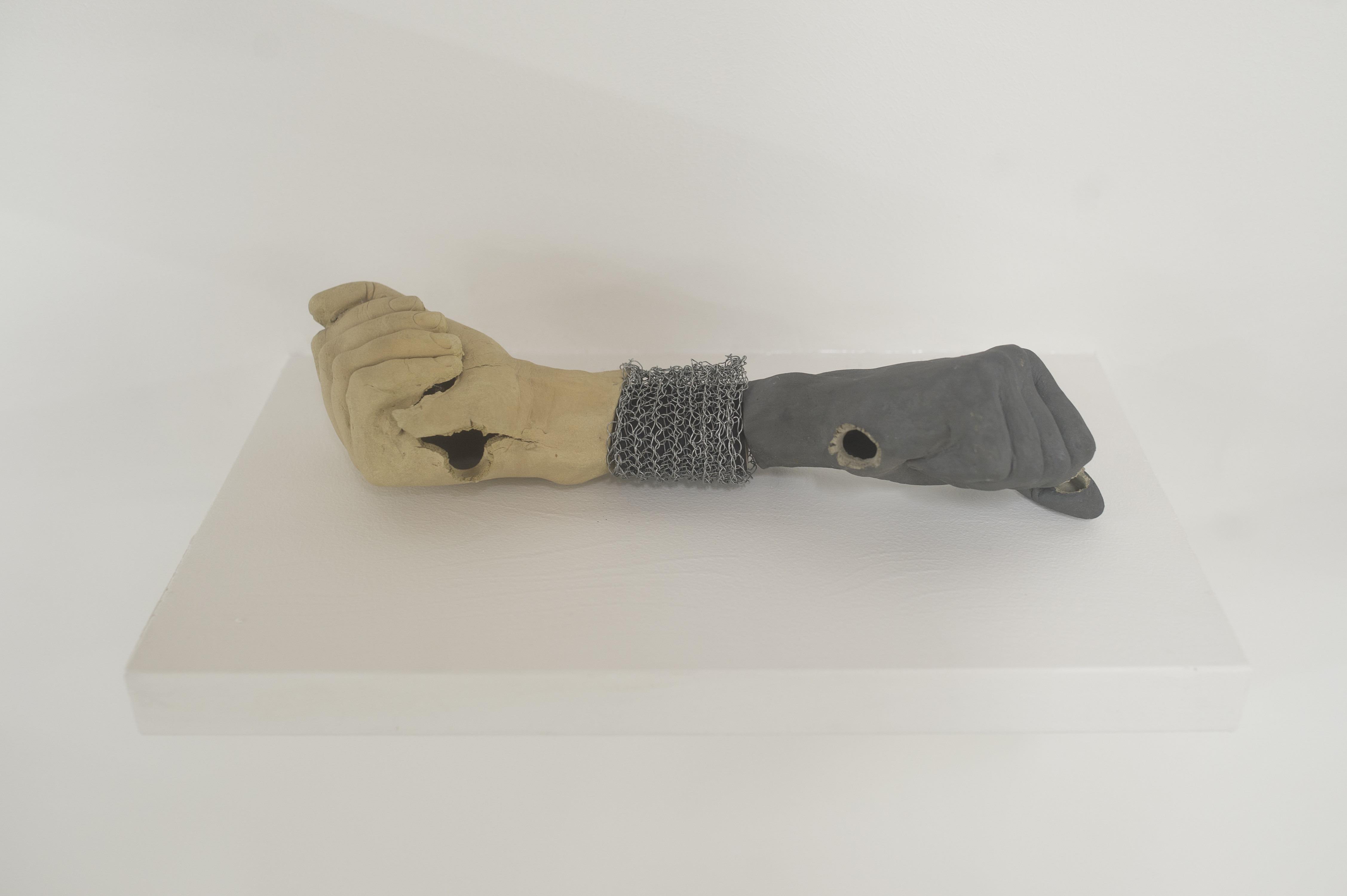 Double Fist, 2022, 2 pugni di ceramica esplosi, bracciale uncinetto di metallo, cm 36x11x9