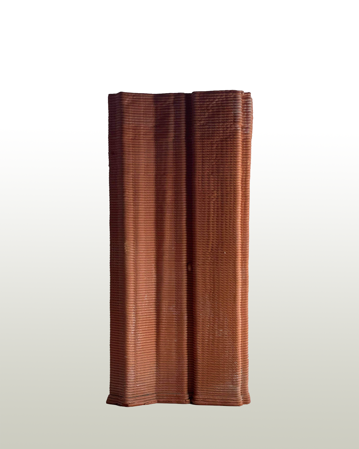 an orange vase stands on a white to grey gradient