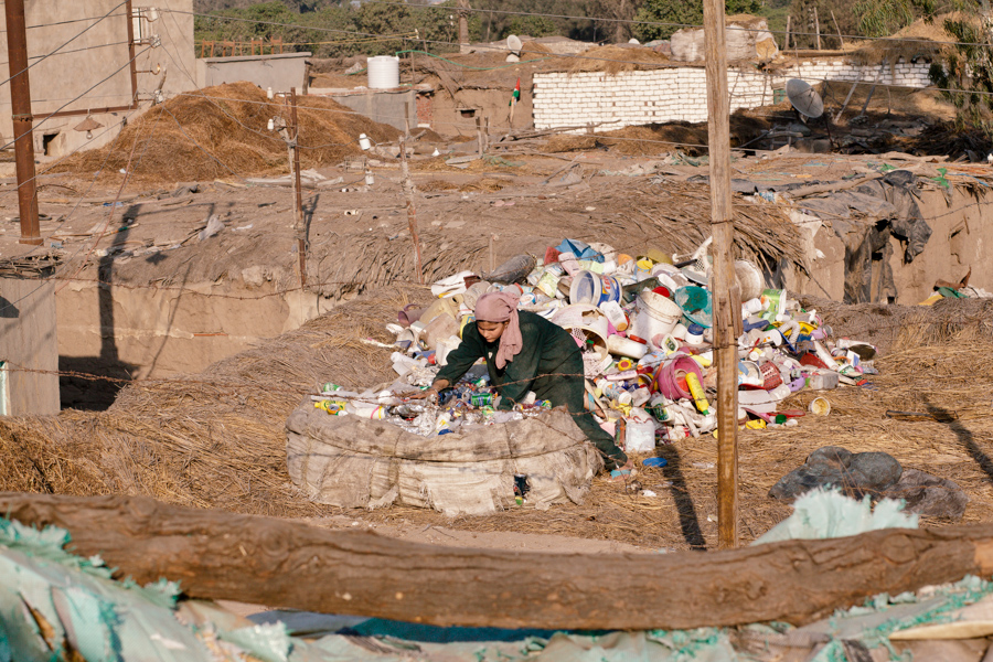 Cette jeune femme trie des bouteilles en plastique sur le toit de sa maison.