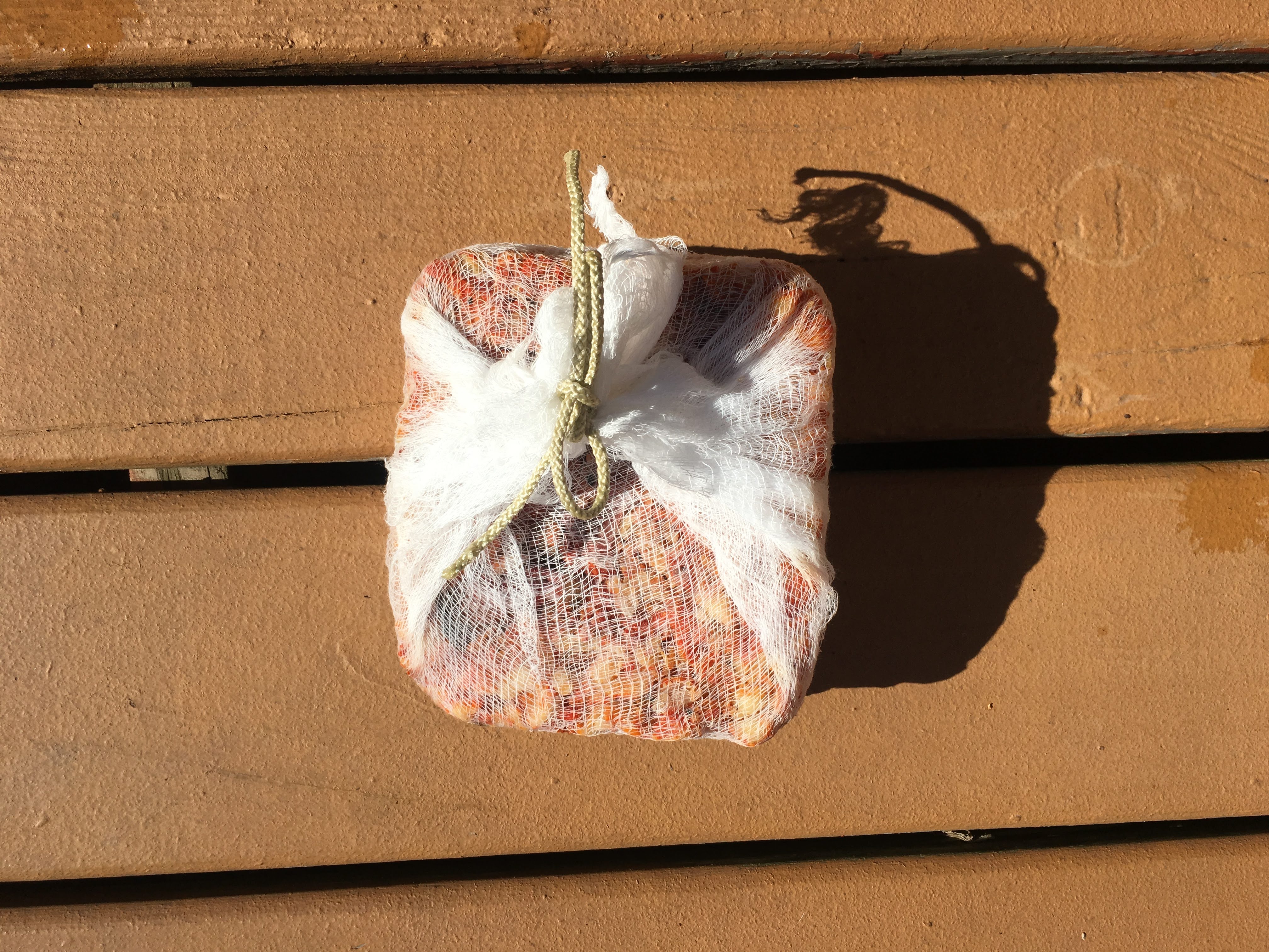 a cheesecloth wrapped block of lobster mushrooms resting on the sun-washed deck.