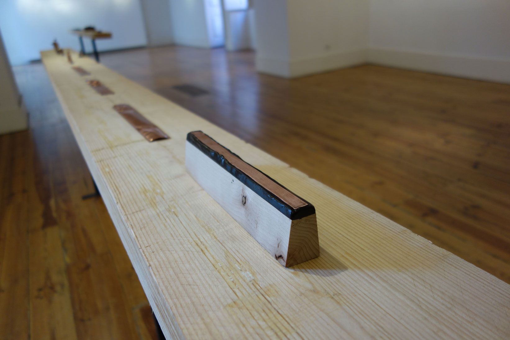 Exhibition view, 2018, wooden block, chasers pitch, copper plate, 26 x 3,5 x 5,3 cm
