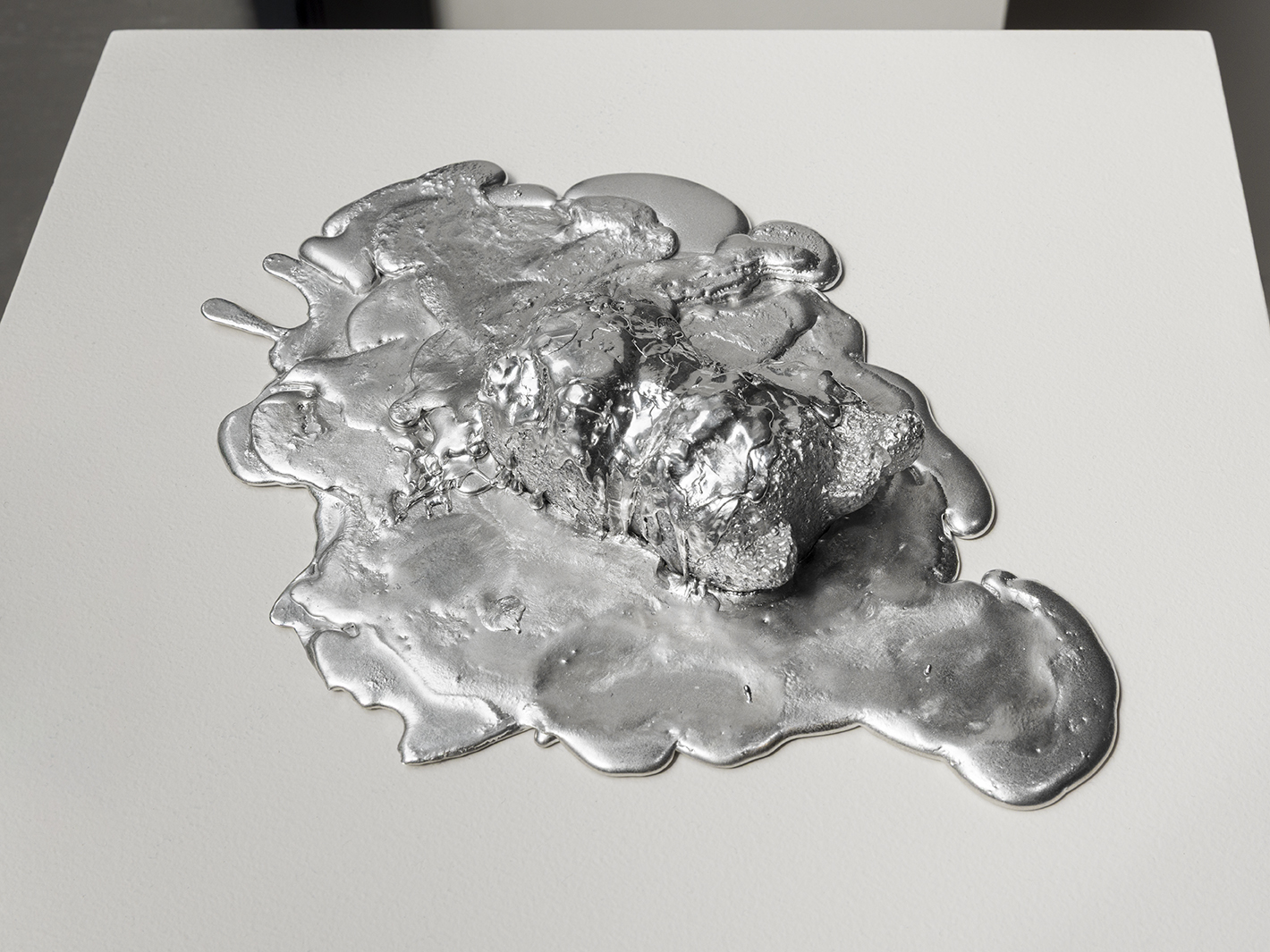 Jennifer and Kevin McCoy, Spill Series: Cat, 2019. Cast and poured tin alloy, 1 1/2 x 10 1/2 x 7 1/2 inches. Photo by Etienne Frossard.