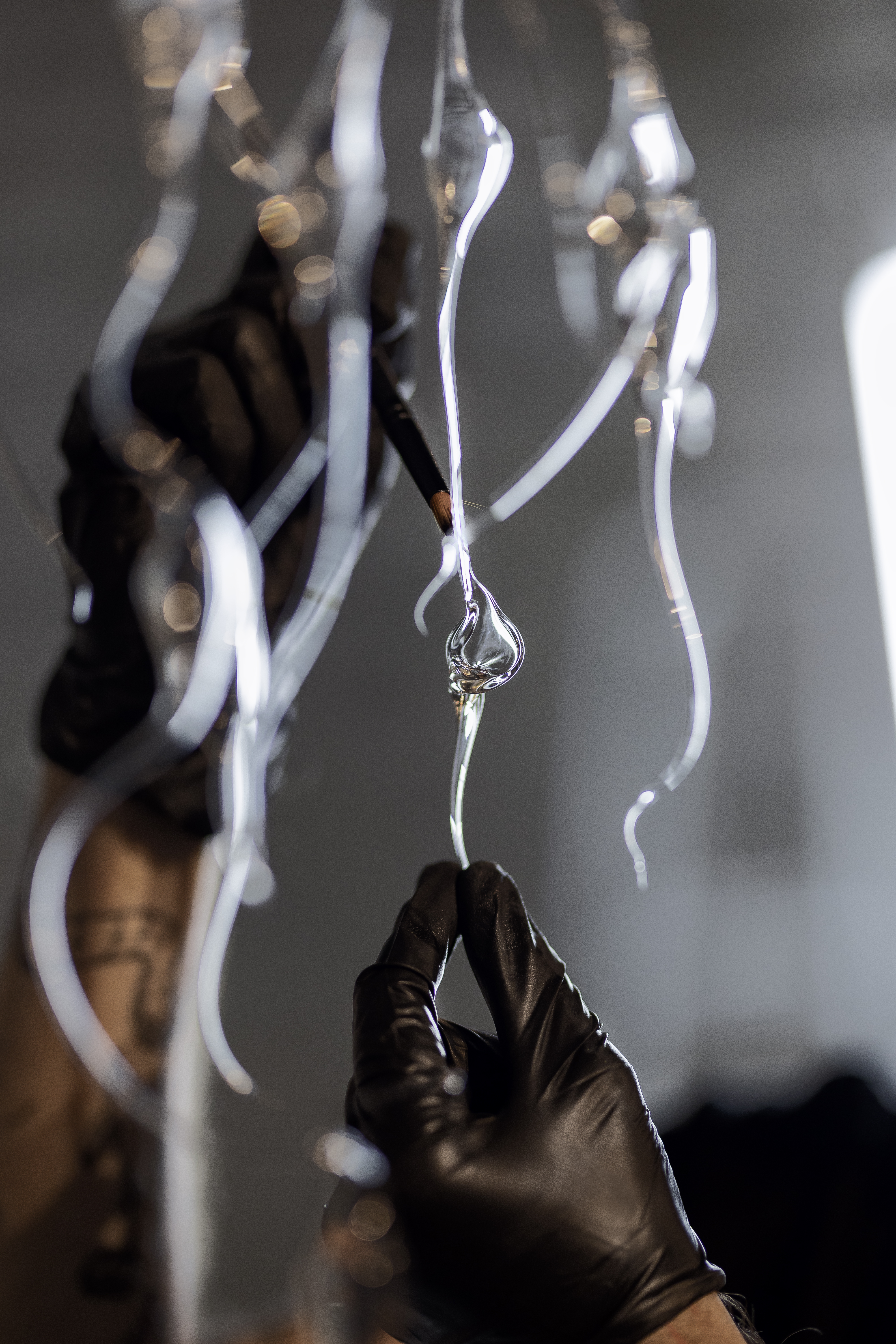 Detail of hand cleaning Chandelier made with blown glass exhibited at Capella de Sant Nicolau, Girona. Pelagia Noctiluca from Plaja Studio