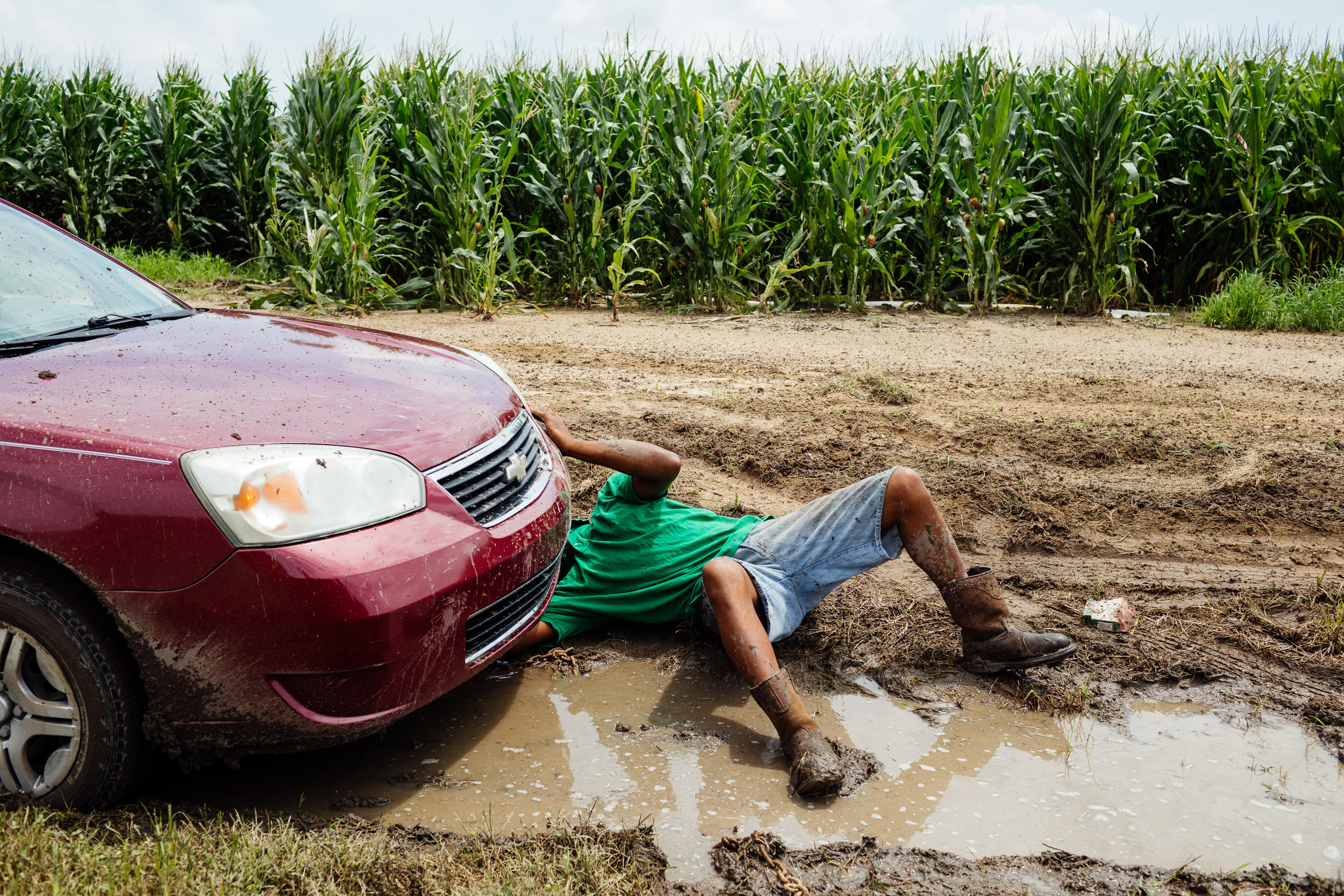 A man works to get his car out of a ditch after driving off the road outside of Quito, Miss.